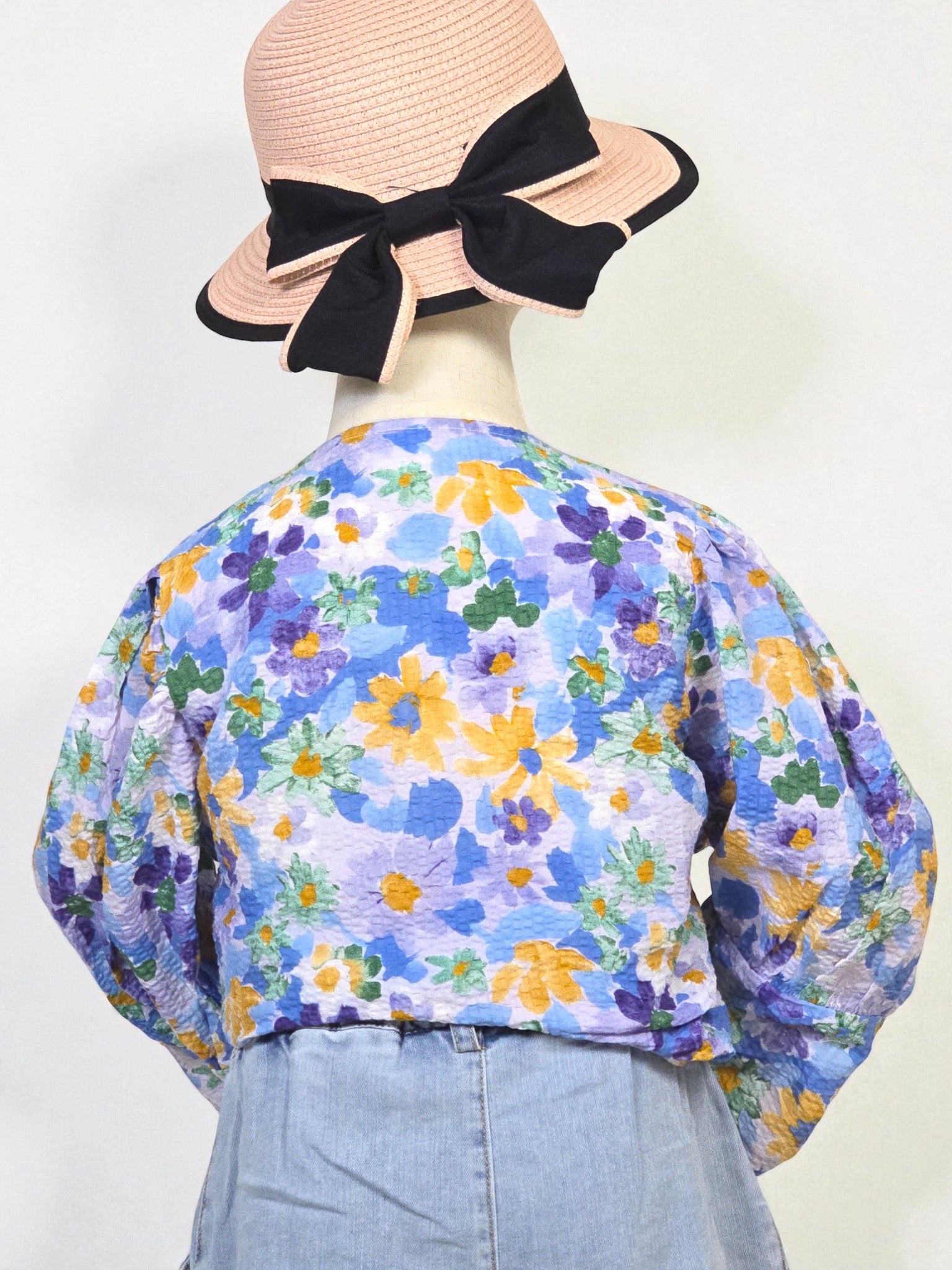 Kids clothing Mannequin wearing a floral blouse and denim shorts with a hat on a white background. Blue