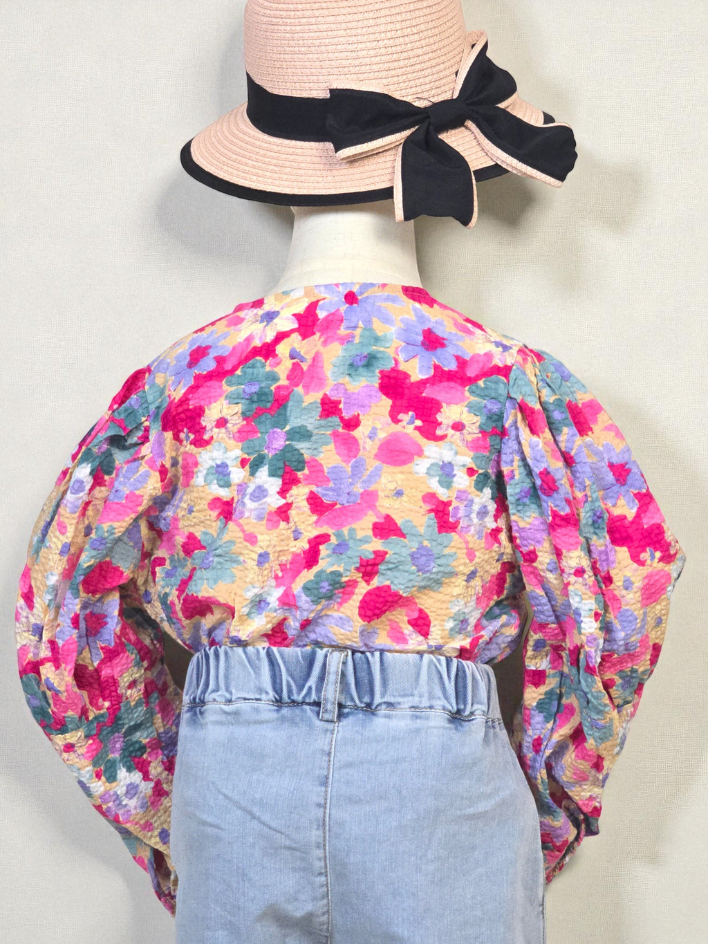 Kids clothing Mannequin wearing a floral blouse and denim shorts with a pink hat on a white background. Pink
