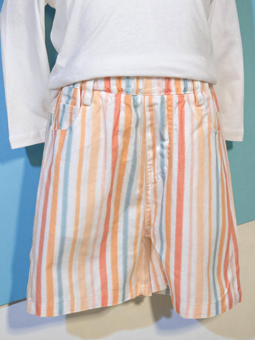 Multicolored striped shorts on a mannequin against a blue background