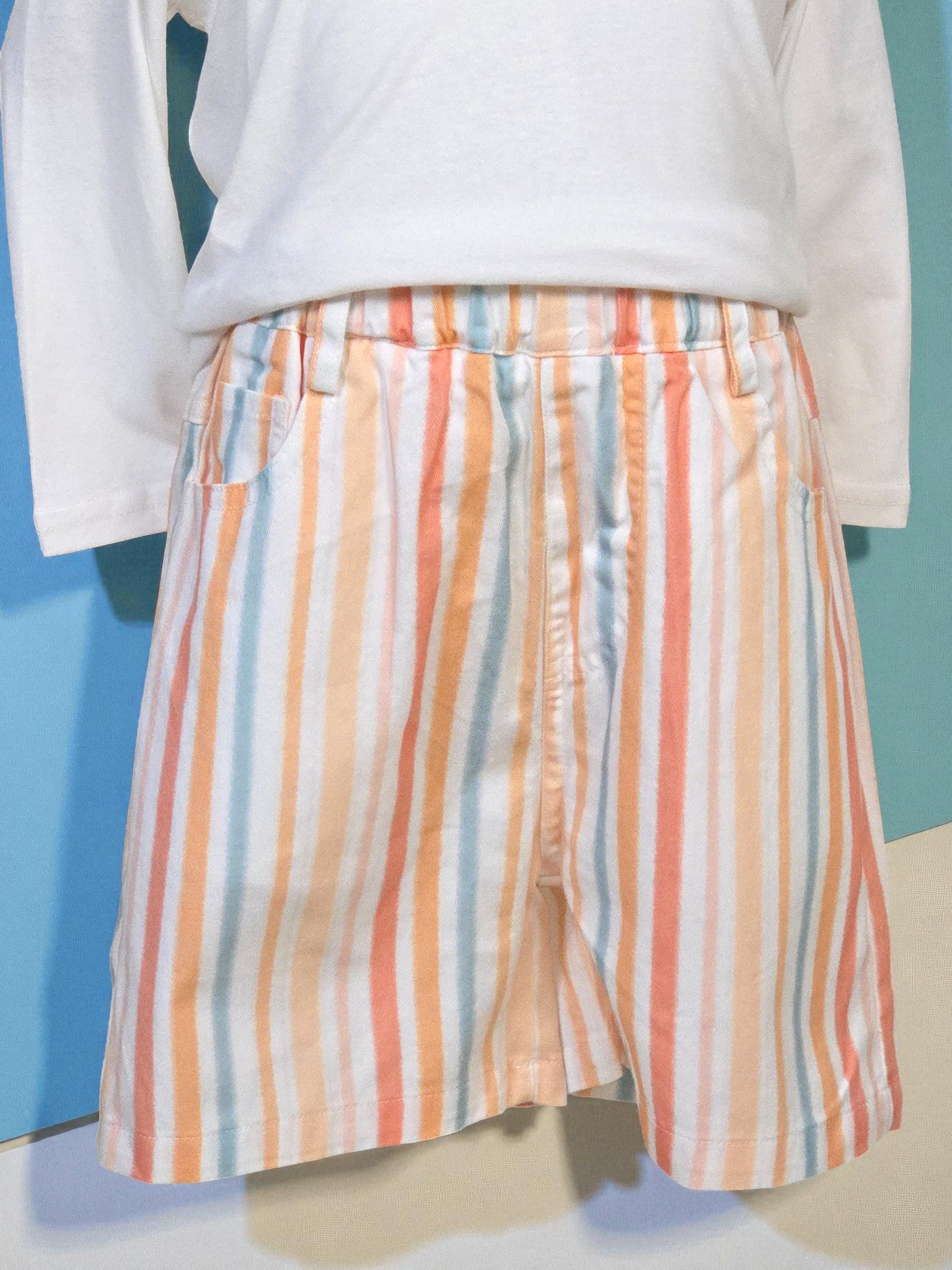 Multicolored striped shorts on a mannequin against a blue background