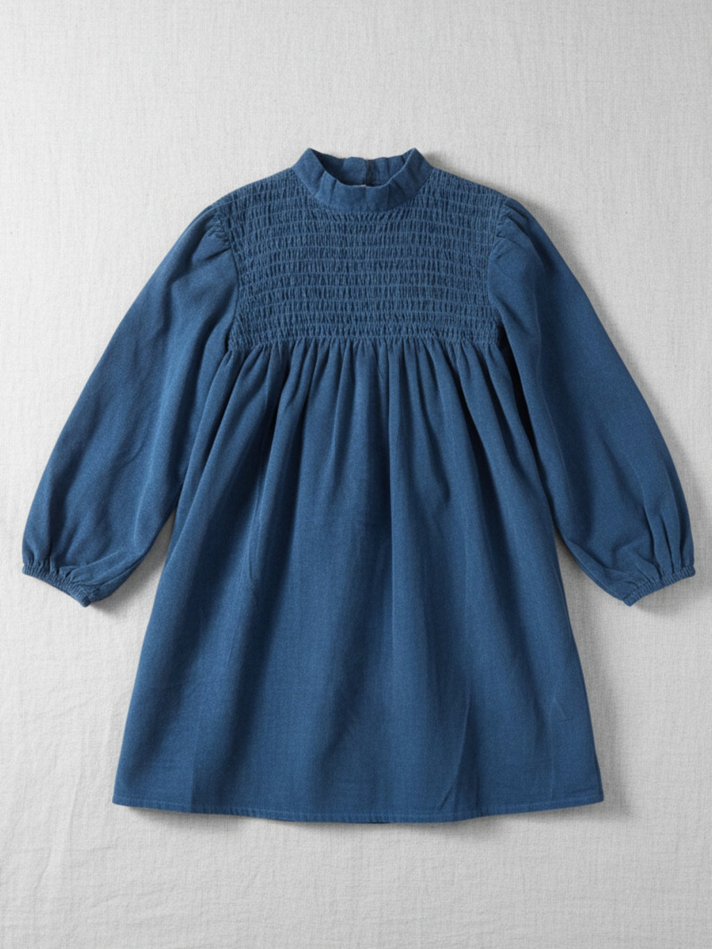 Kids long-sleeve deep blue corduroy dress featuring a high smocked bodice and voluminous balloon sleeves