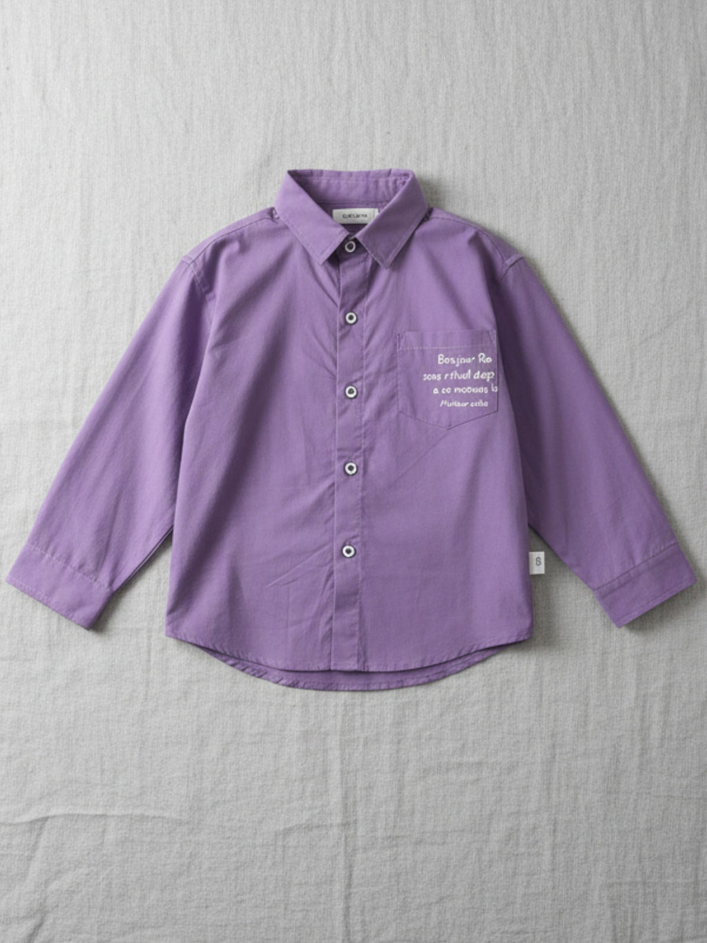 Kids purple long sleeve button-down shirt with a "Bonjour" script print on the chest pocket 