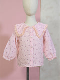 Pink checkered blouse with ruffled collar on a mannequin against a pink and gray background. Pink