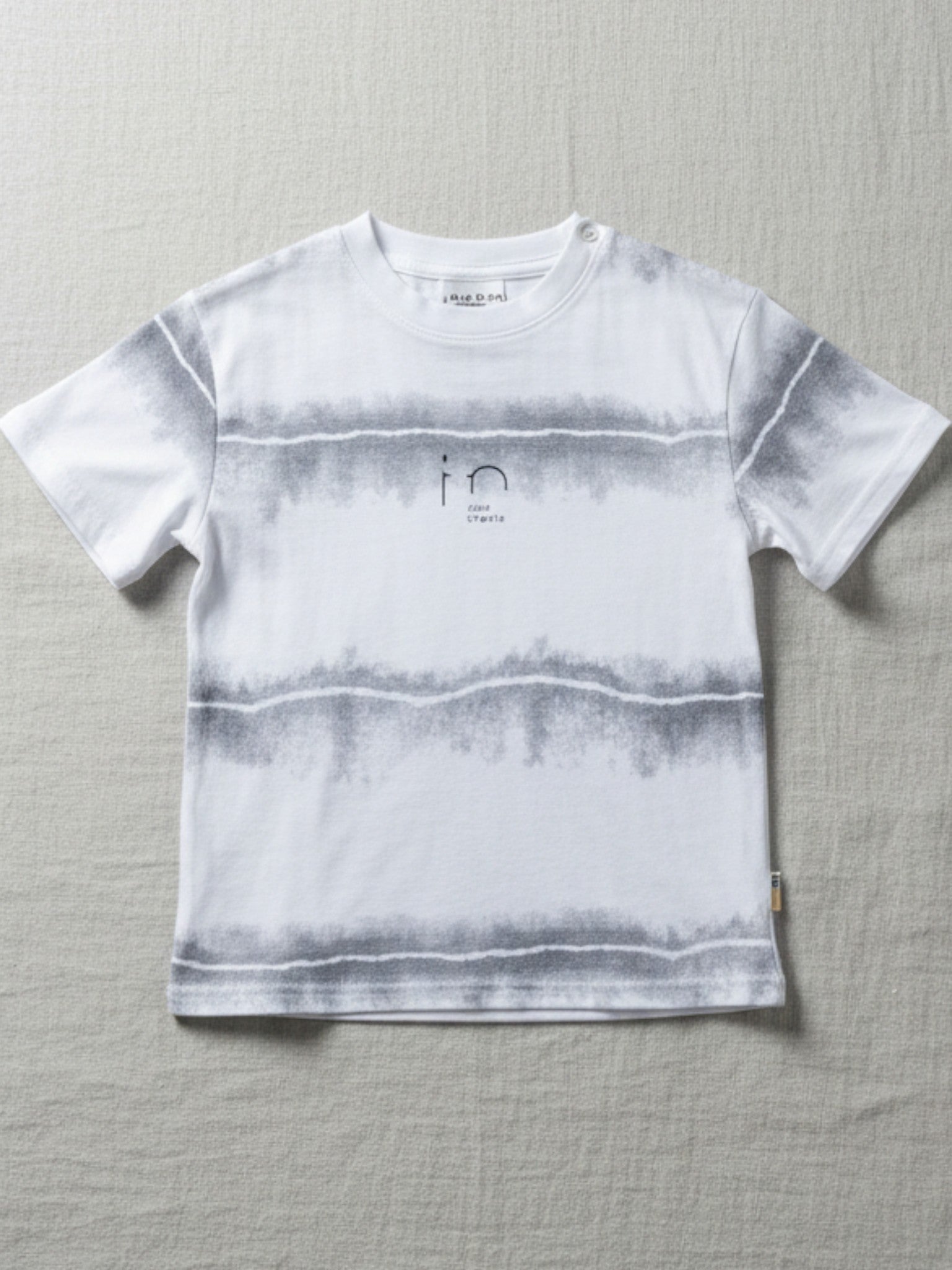 Children's white short-sleeve t-shirt featuring three horizontal gray watercolor-effect stripes and a minimalist "in" graphic on the chest.