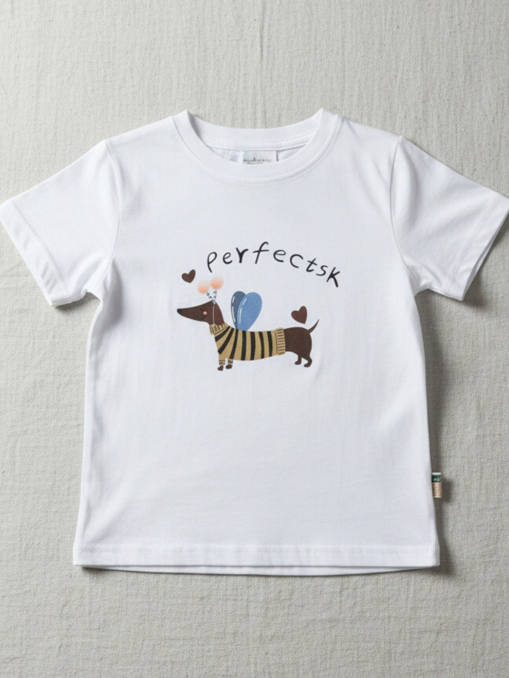 Children's white short-sleeve t-shirt featuring a central illustration of a dachshund wearing a striped sweater and blue wings with the text "perfectsk" above.