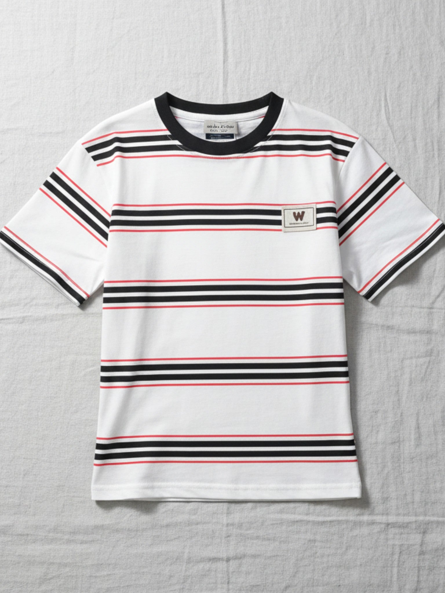 Children's white short-sleeve t-shirt featuring horizontal black and red stripes, a black crew neck collar, and a small "W" patch on the chest.