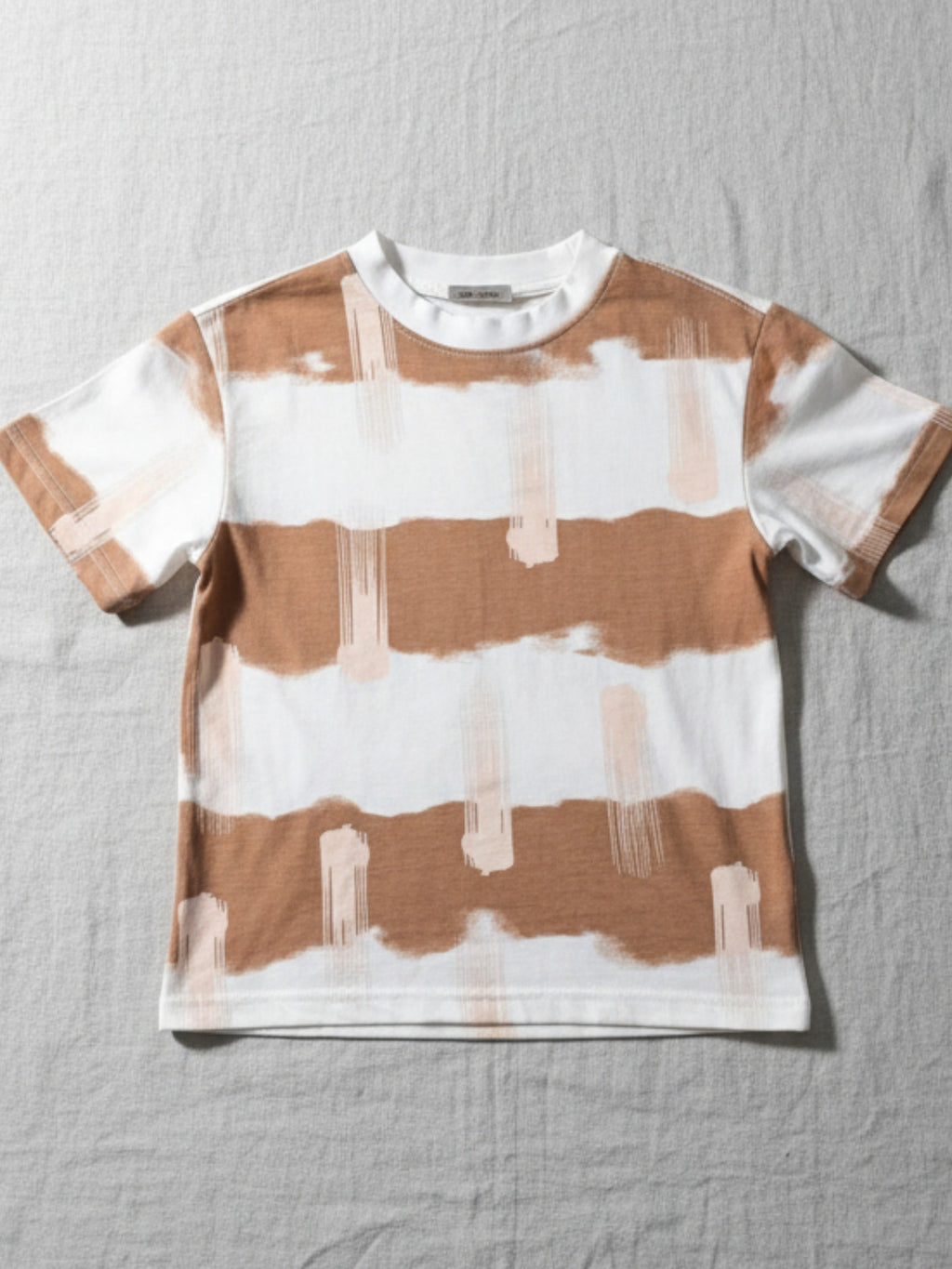 Striped t-shirt with brown and white pattern. High-quality and affordable kids wear from Australia, featuring clothing everyday play, dress up events or for the playground. machine-washable cotton. perfect blend of style and durability for boys and girls. Easy care kids clothes. Toddler/child [item] Australia. Affordable kids wear