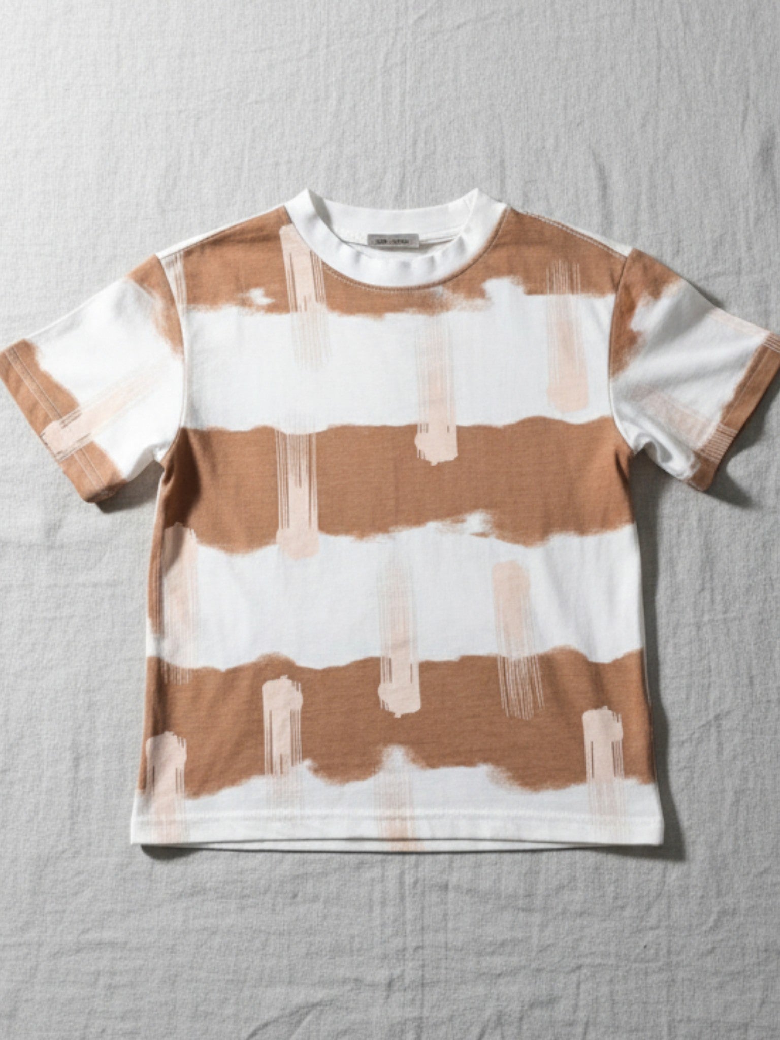 Striped t-shirt with brown and white pattern. High-quality and affordable kids wear from Australia, featuring clothing everyday play, dress up events or for the playground. machine-washable cotton. perfect blend of style and durability for boys and girls. Easy care kids clothes. Toddler/child [item] Australia. Affordable kids wear