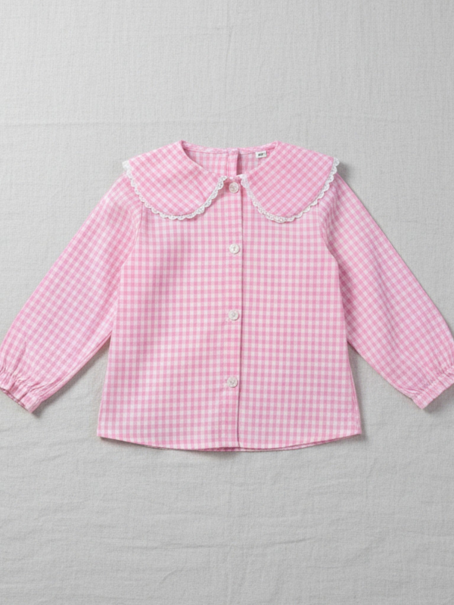 Girls' pink and white gingham long-sleeve blouse featuring a wide scalloped collar, puff sleeves, and a button-down front.