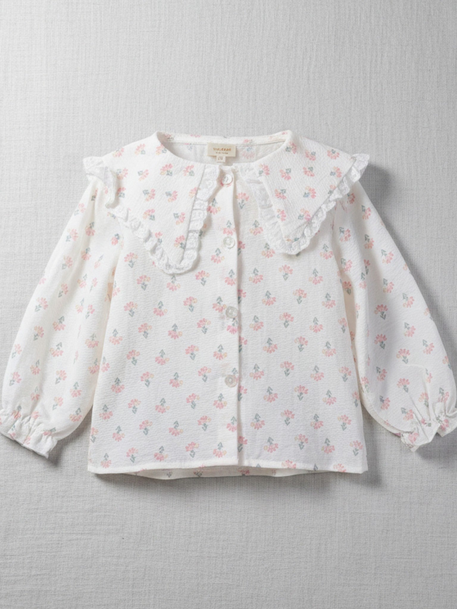 Girls' long-sleeve blouse with a delicate pink floral print and a white lace-trimmed vintage collar in a soft, textured fabric.