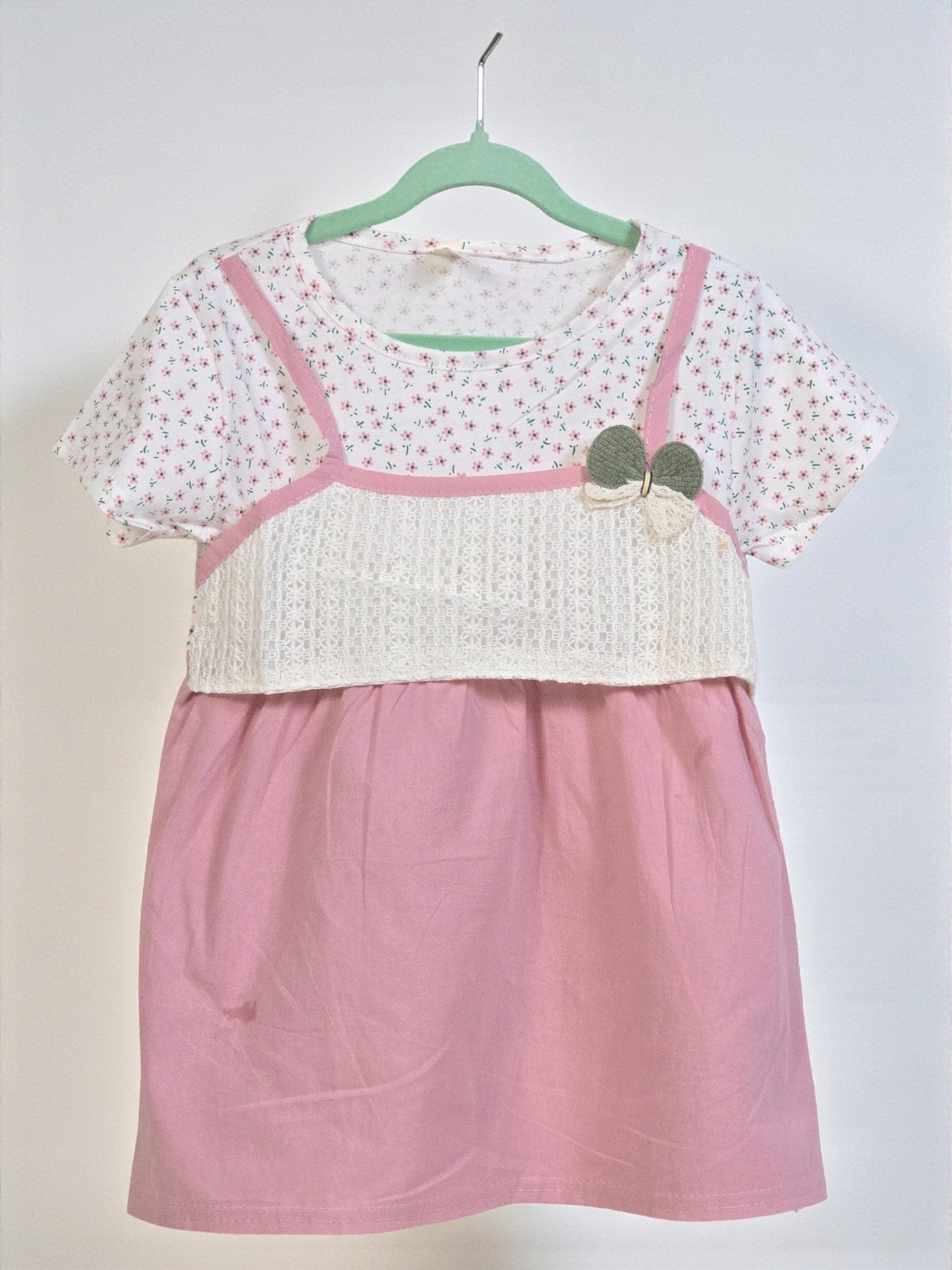 Pink dress with white top on a hanger against a plain background. Pink 2