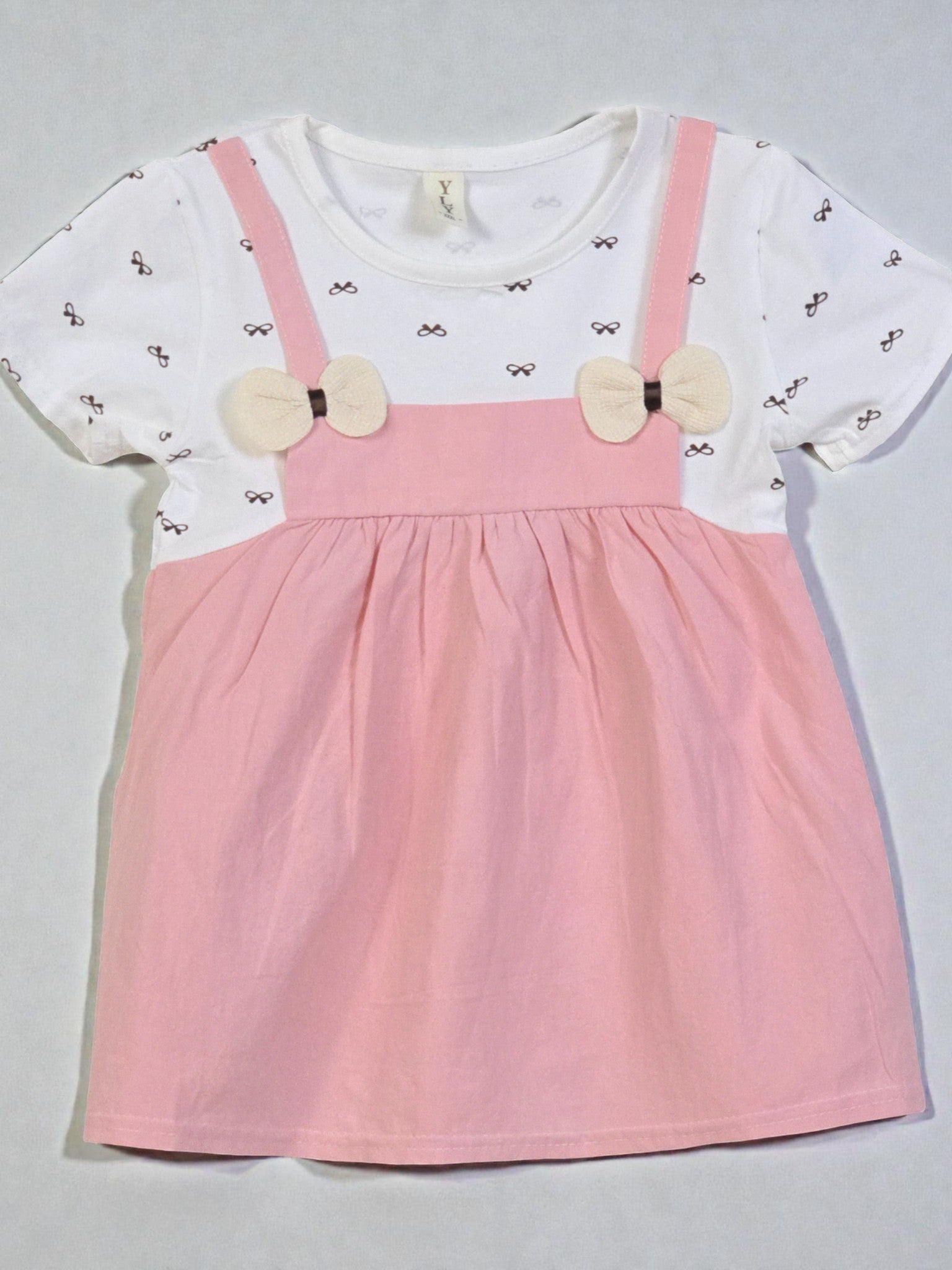 White shirt with bow details and pink suspenders on a gray background. Pink 1