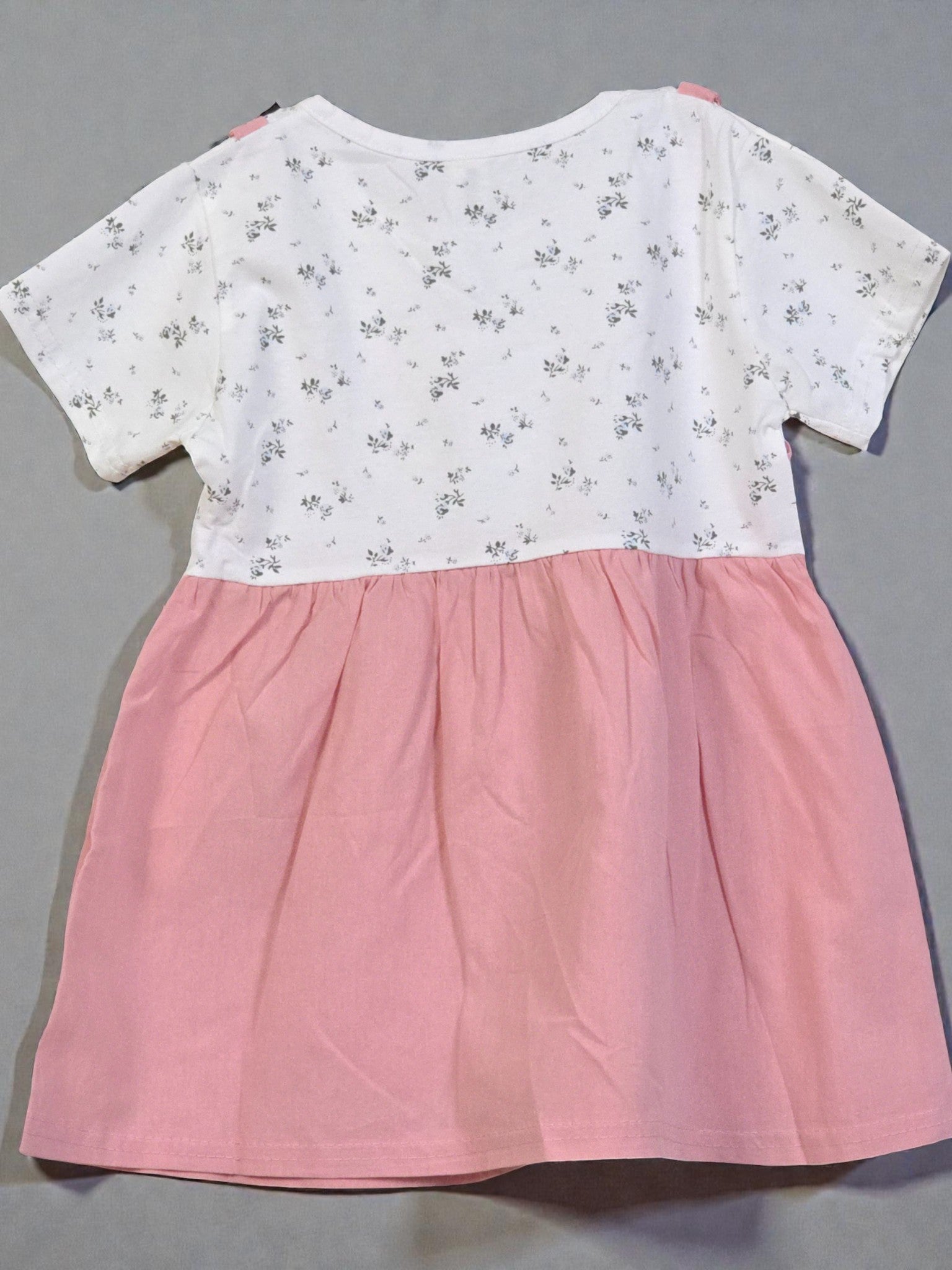 Pink dress with floral patterned top on a gray background. Pink 4