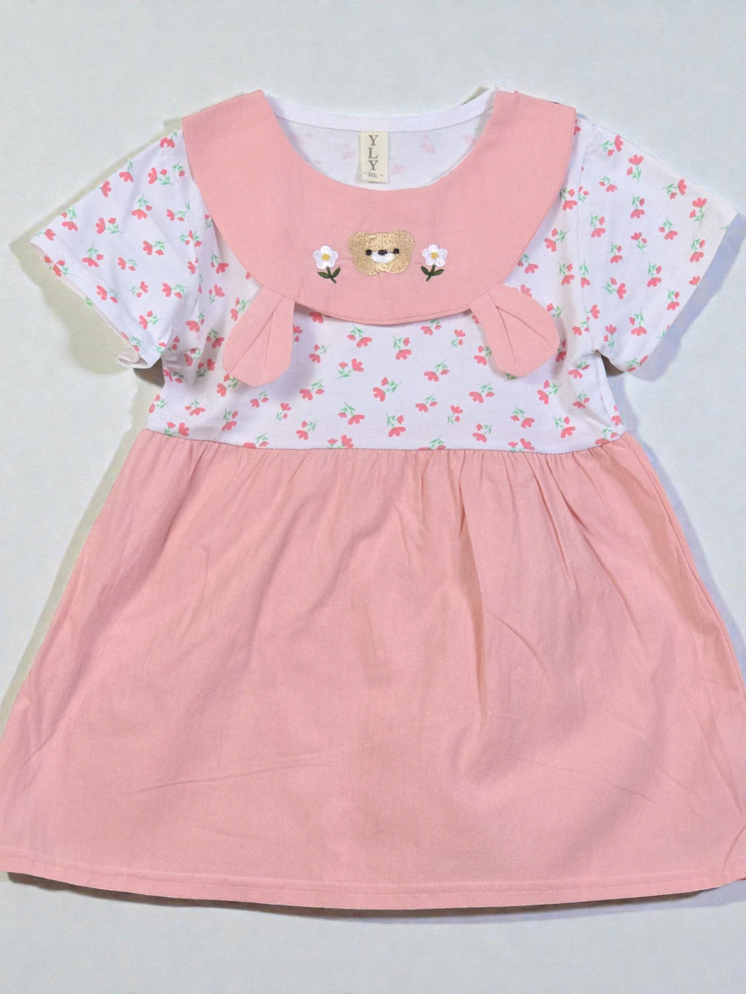 Pink dress with floral patterned top and white collar on a light gray background. Pink 7