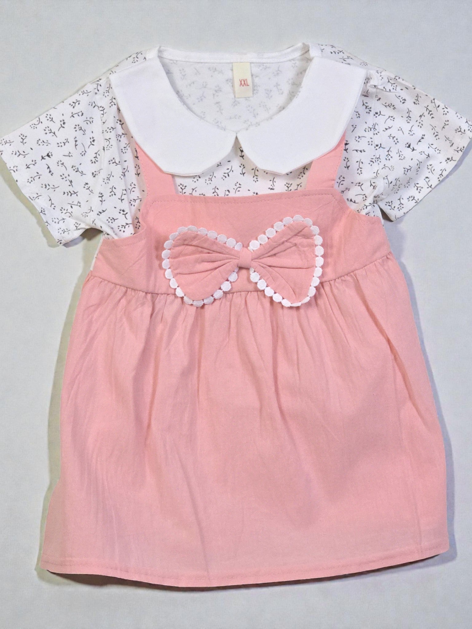 Pink dress with a bow and white lace top on a gray background. Pink 8