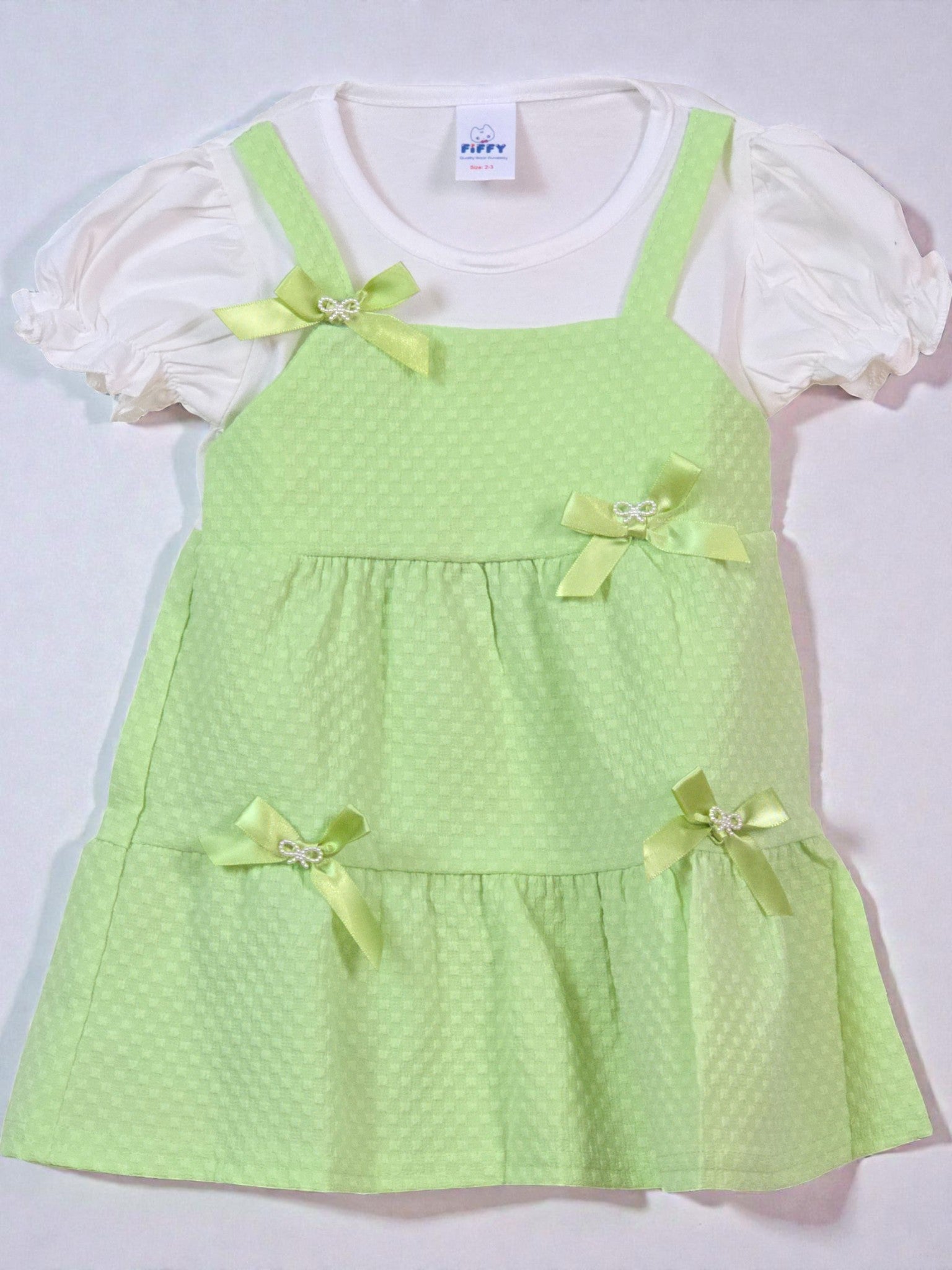 Green dress with bows on a white background. Pistachio