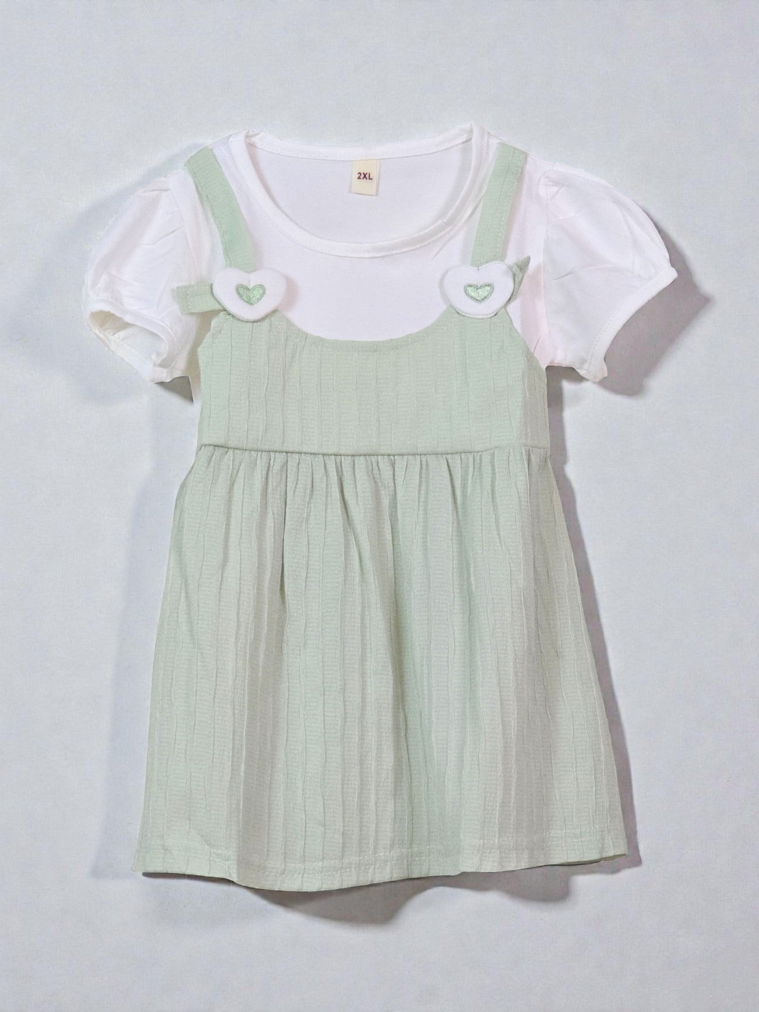 Cute Green pinafore dress with white blouse on a light gray background. Sage