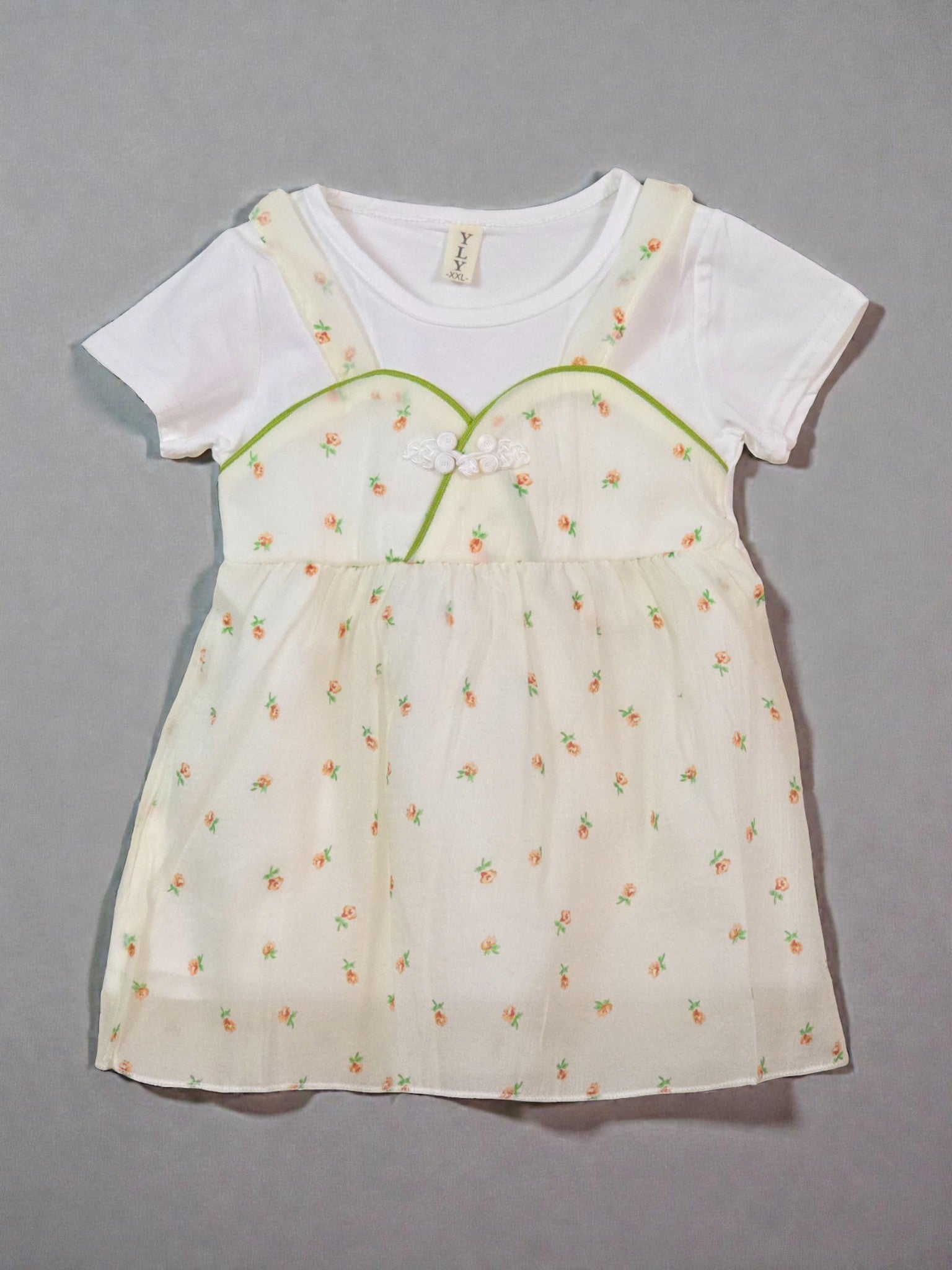 White t-shirt with a floral dress over it on a gray background. Floral