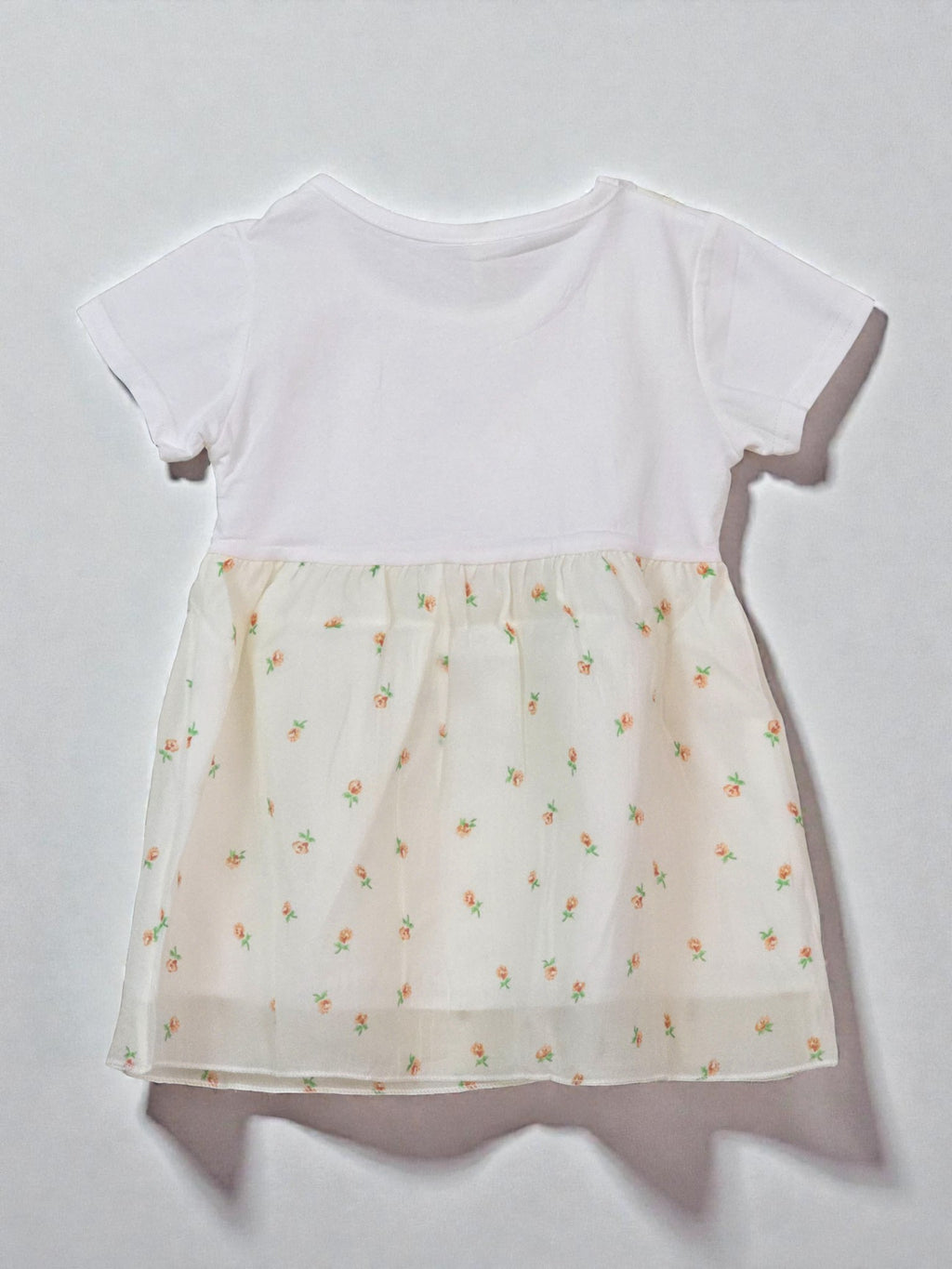 White top with a sheer floral patterned overlay. Floral