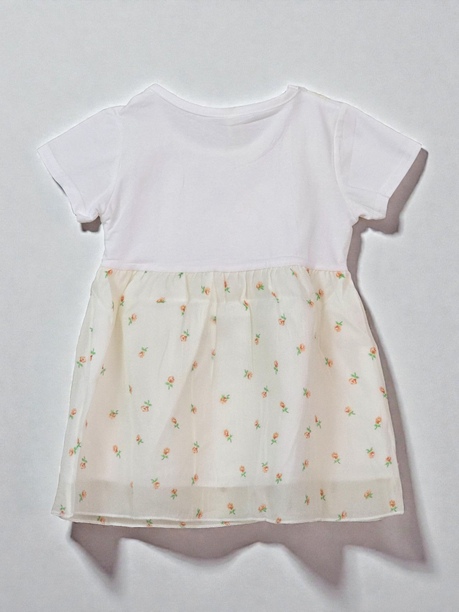 White top with a sheer floral patterned overlay. Floral