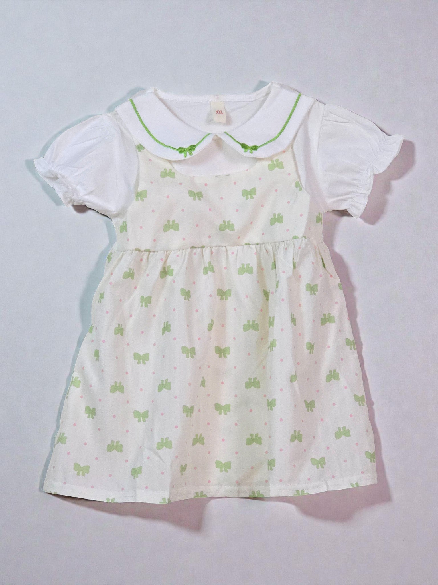 Cute White dress with green butterfly pattern on a light gray background. Butterfly