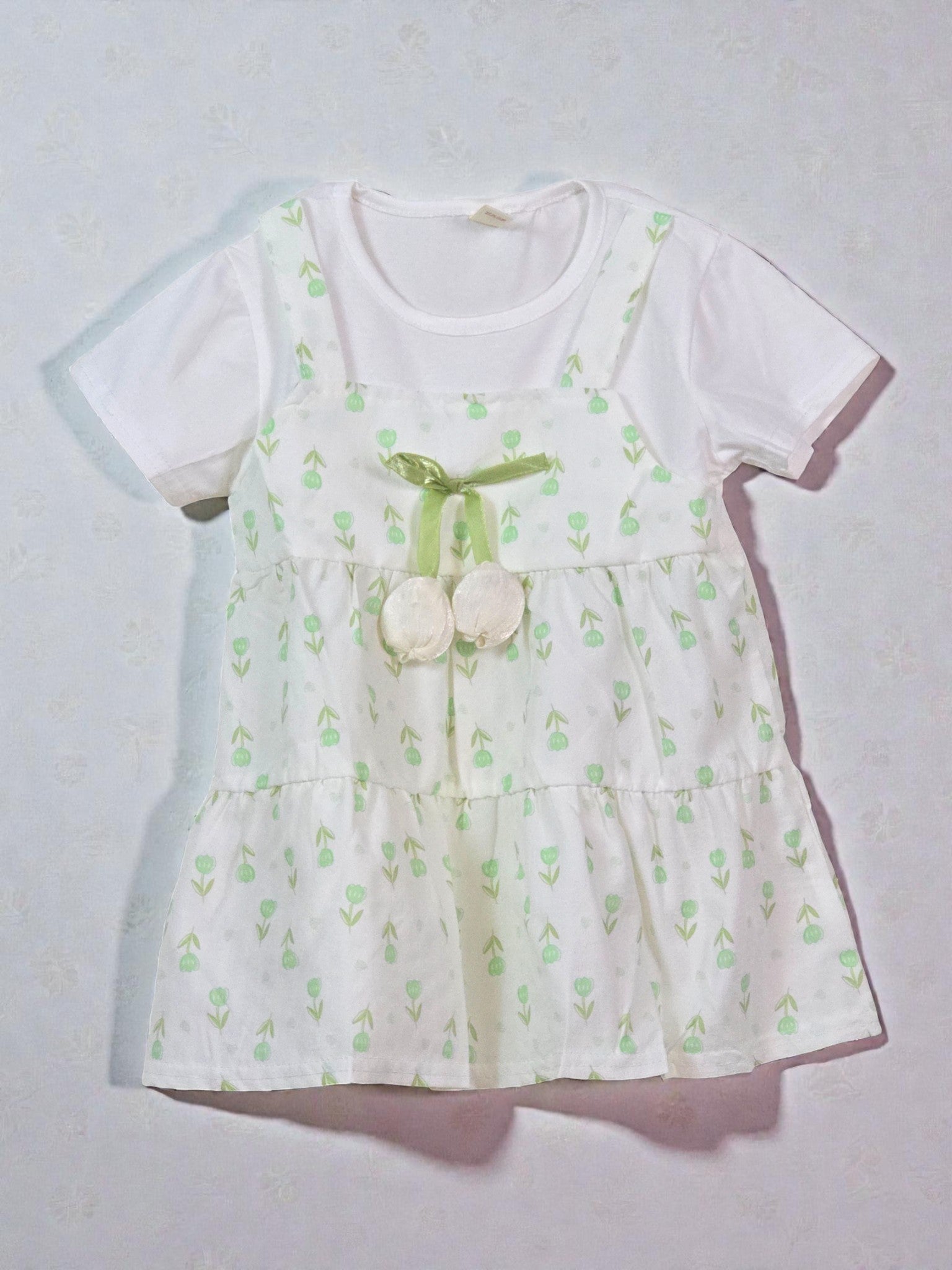 Summer White dress with green floral patterns on a light gray background. Fir