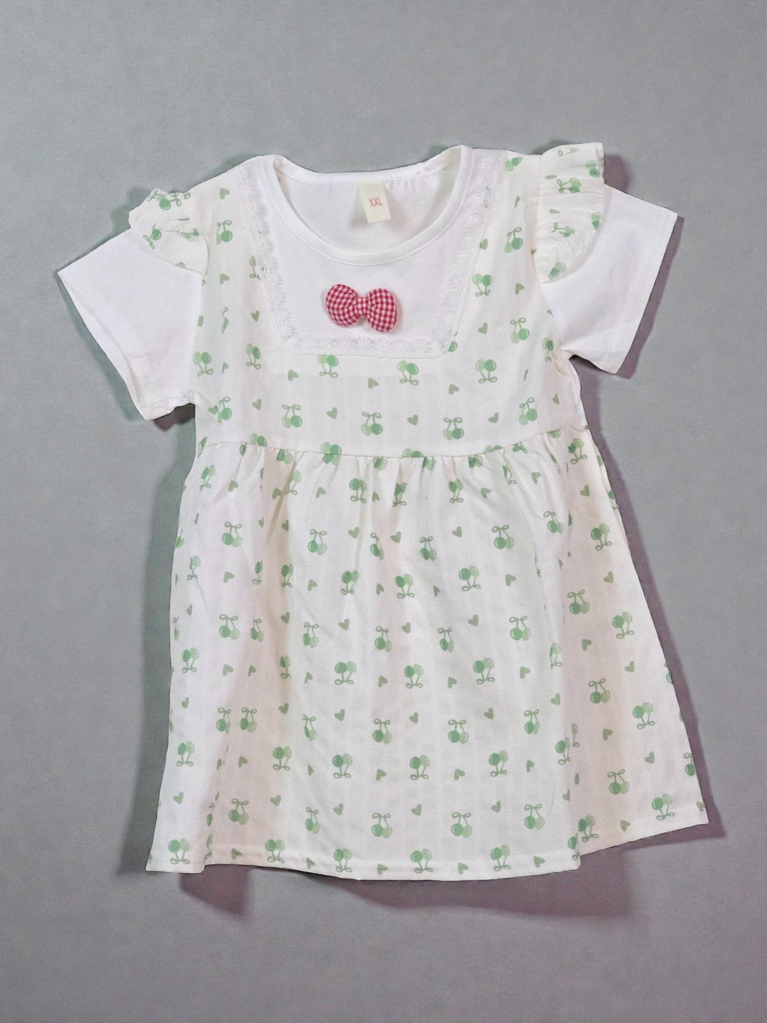 Cute Summer White dress with green floral pattern and red bow on a gray background. Matcha