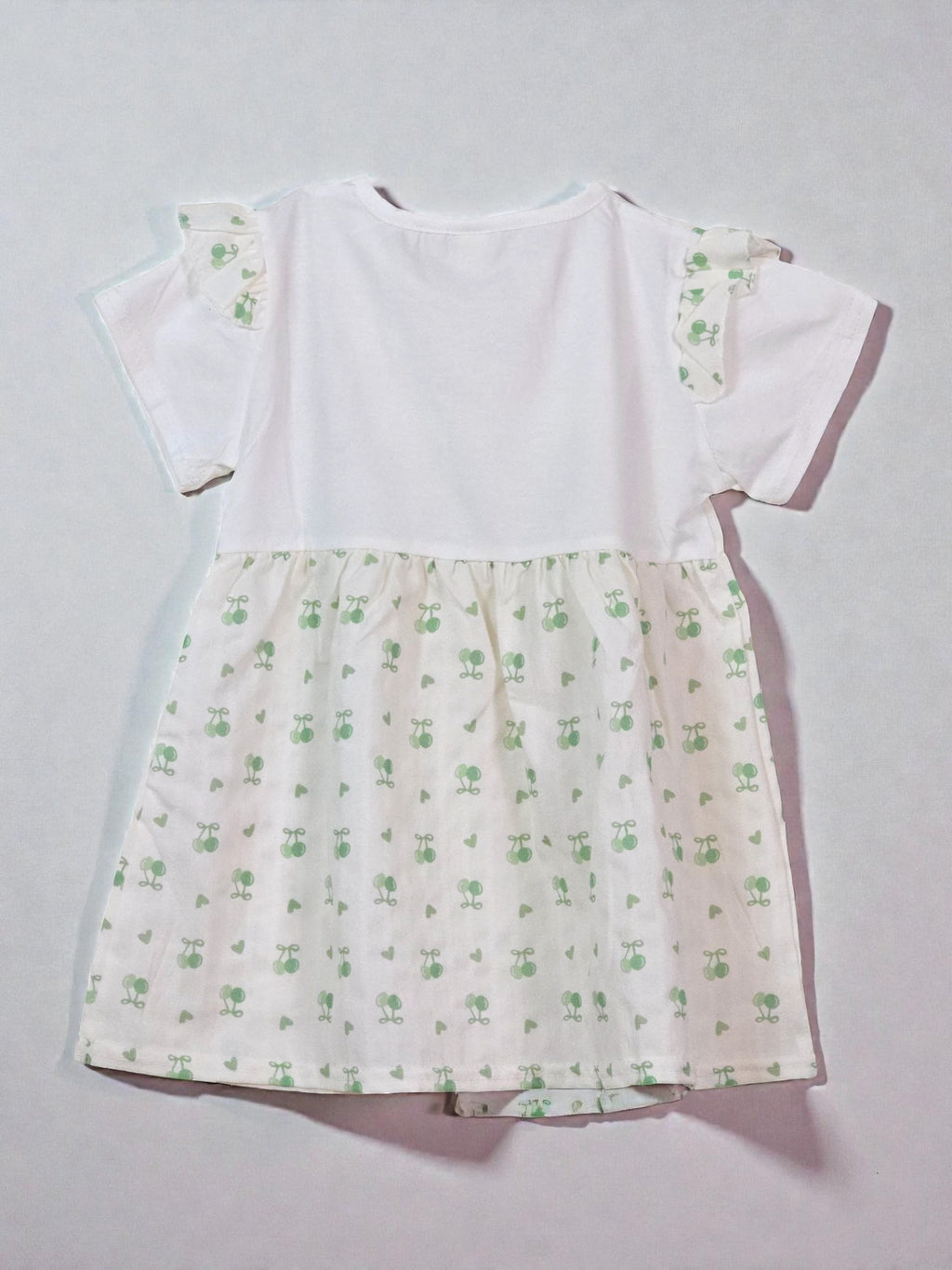 Cute Summer White dress with green floral pattern and red bow on a gray background. Matcha