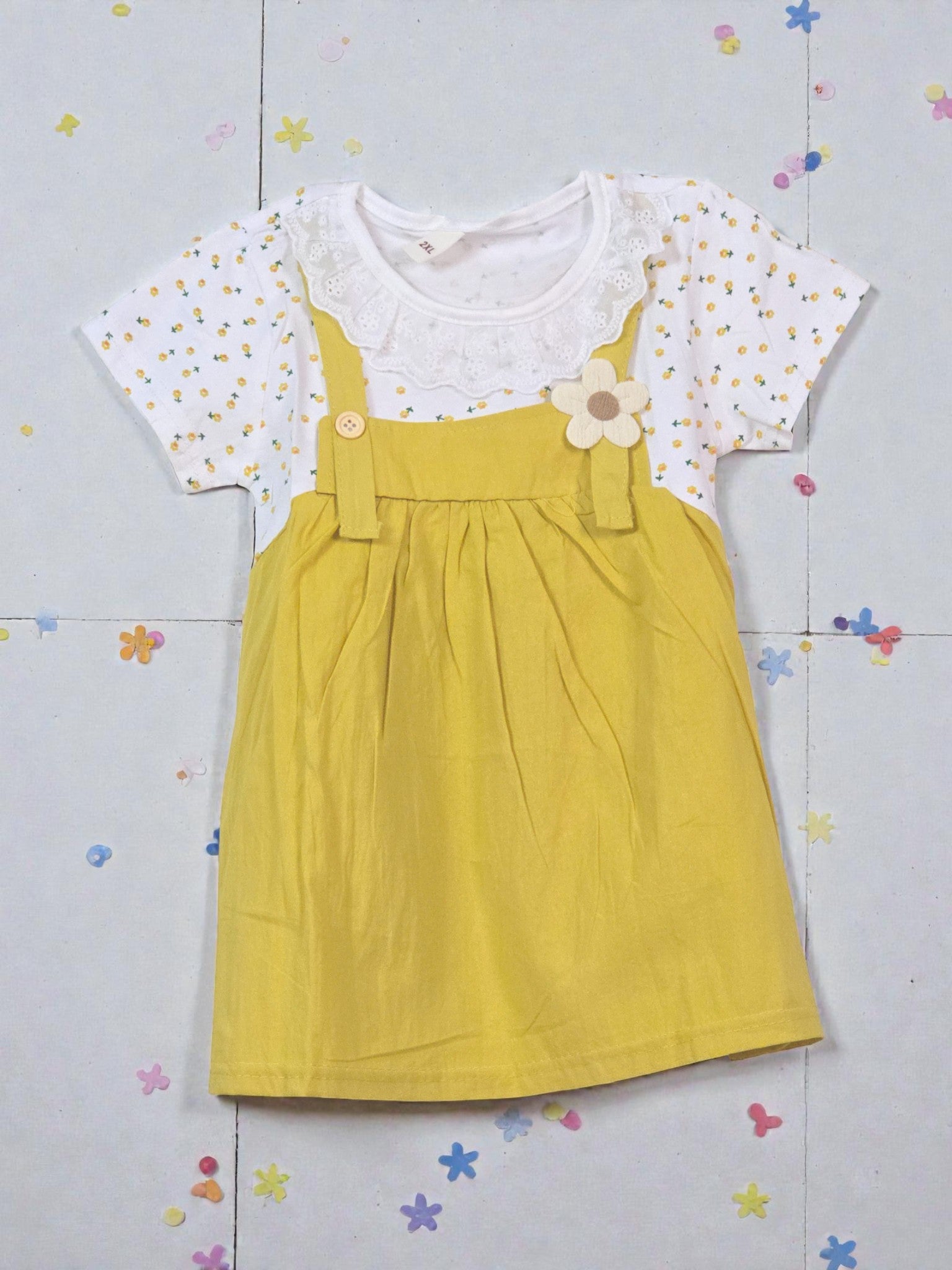 Yellow dress with a white top featuring floral patterns on a tiled background. Sunflower