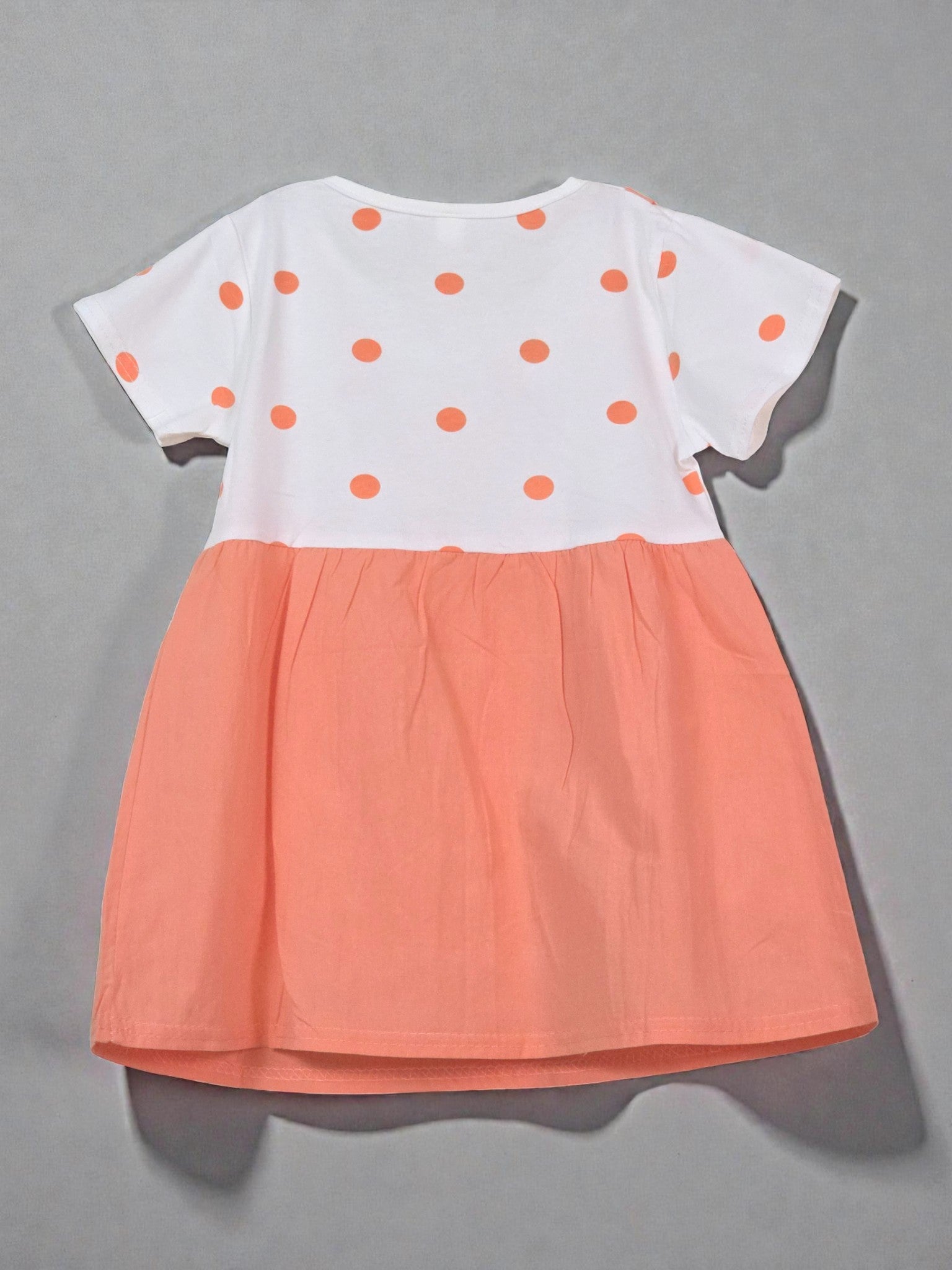 Children's dress with bear design on a light gray background with colorful confetti. Tangerine