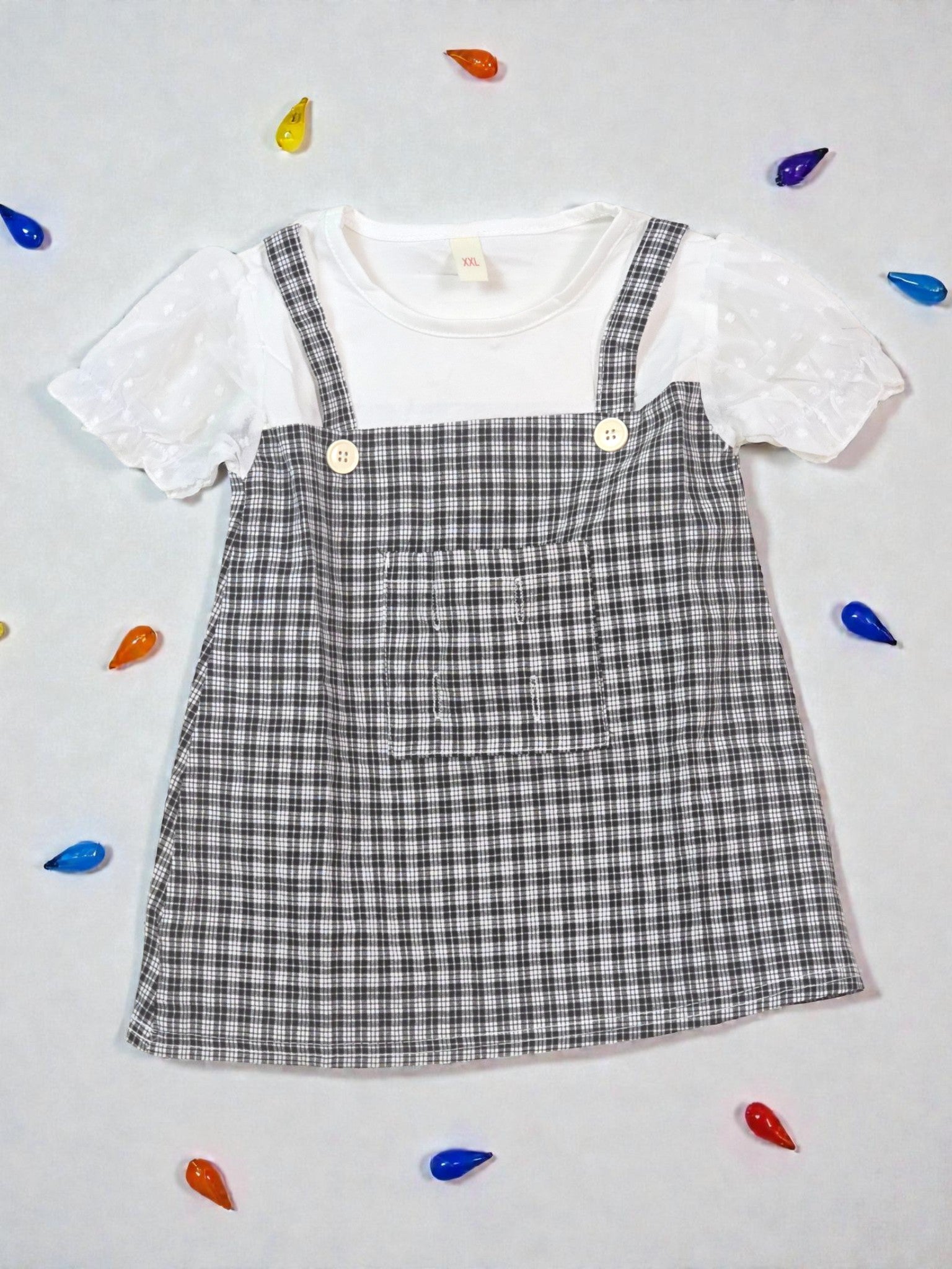 White blouse with ruffled sleeves and a plaid dress on a light gray background. Checkered