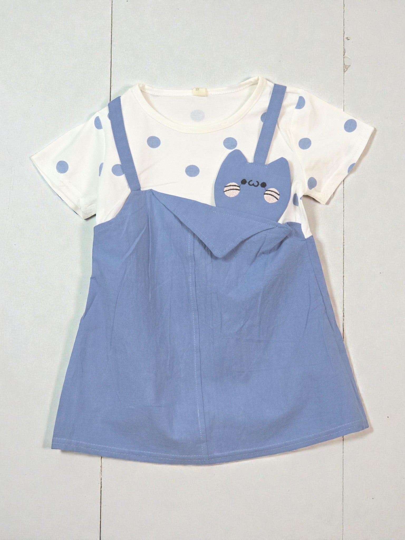 Children's outfit with white top and blue dress on a light gray background Navy