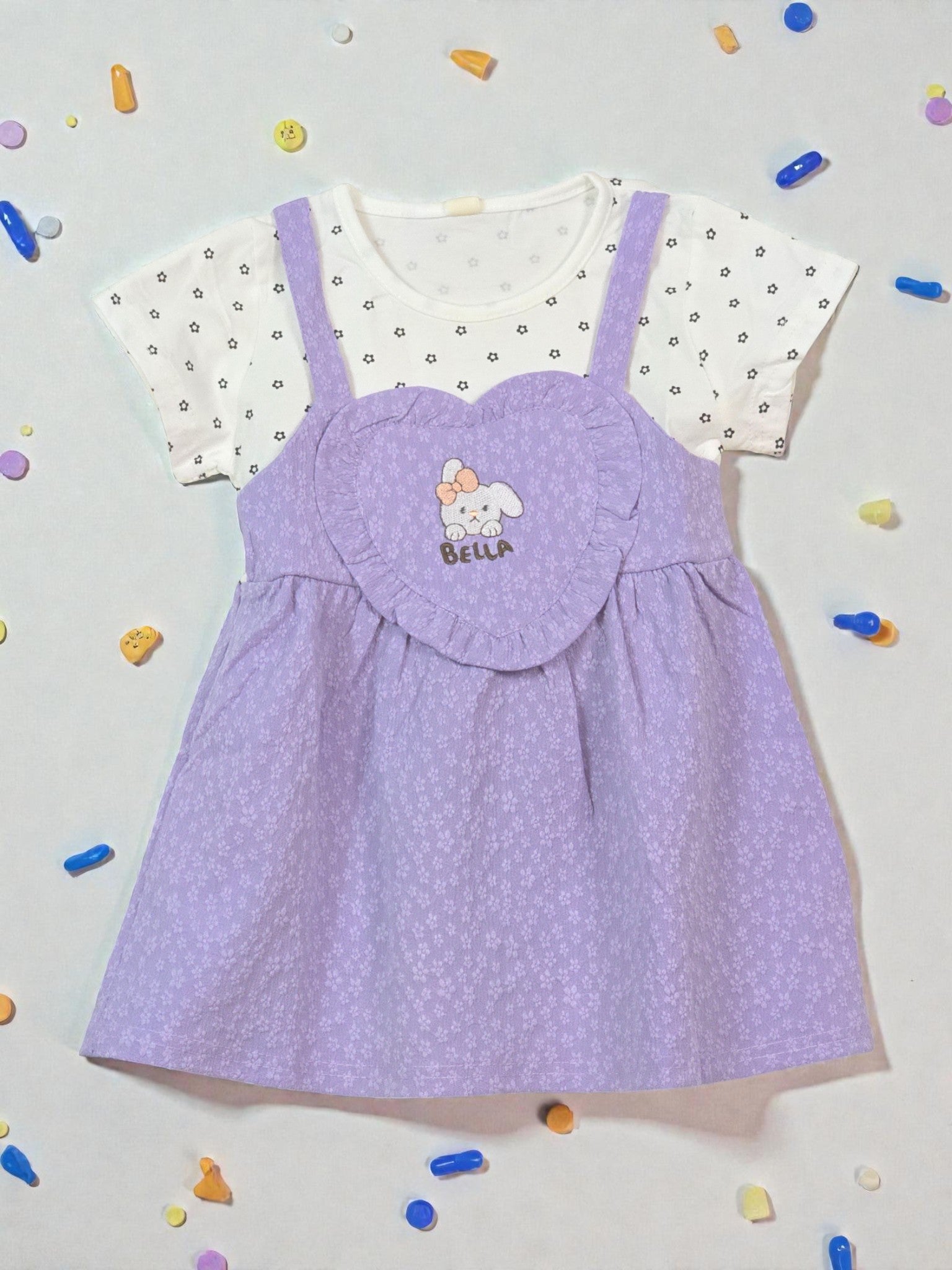 Purple dress with white polka dot top on a light gray background with colorful confetti. Violet