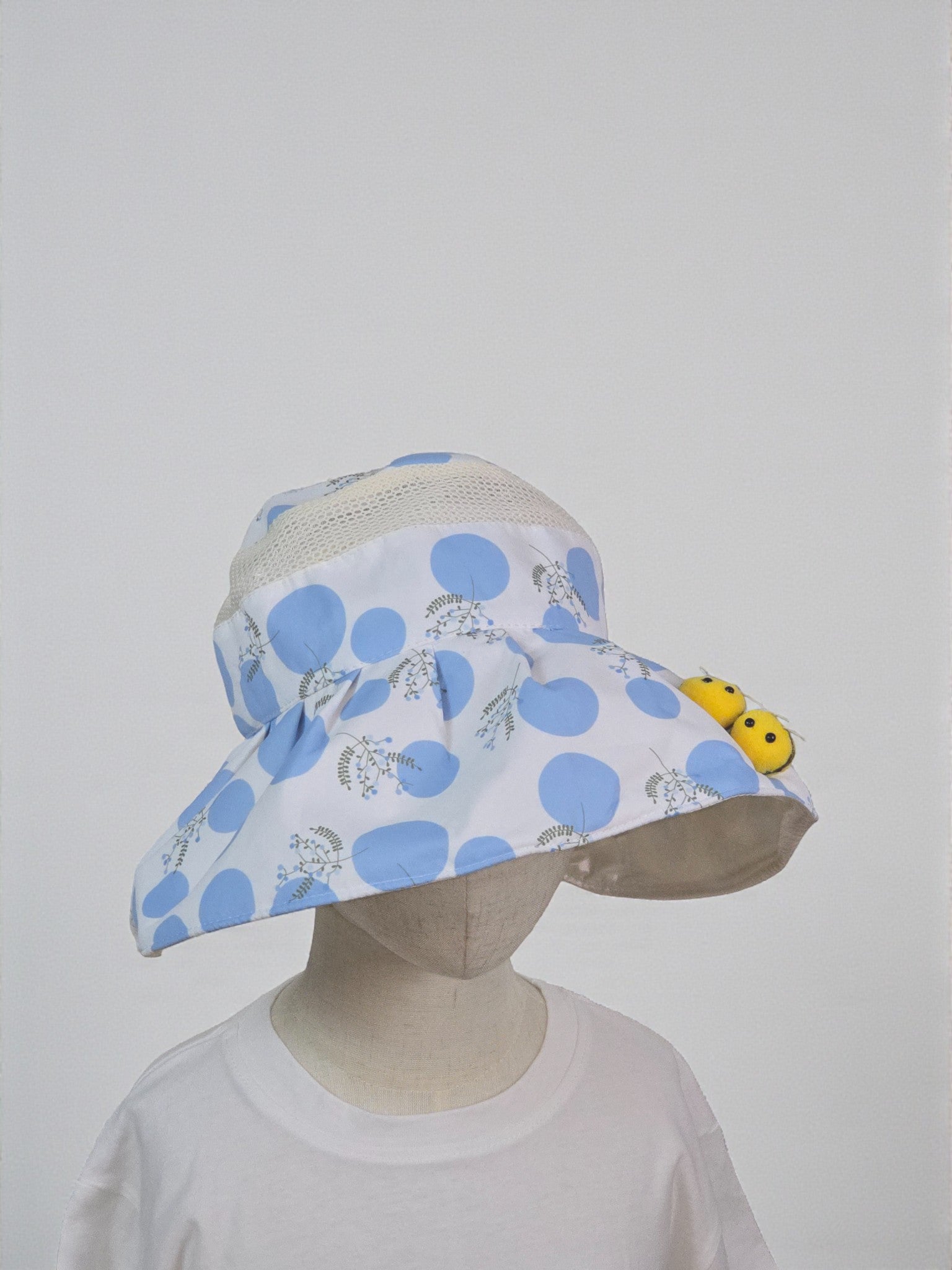 Child's sun hat with blue polka dots and yellow flowers on a white background/ Blue