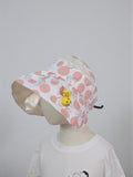 Pink polka dot bucket hat with a yellow character on a mannequin against a white background. Pink