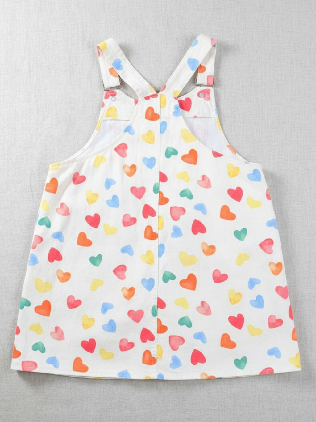 White dress with colorful heart pattern on a gray background