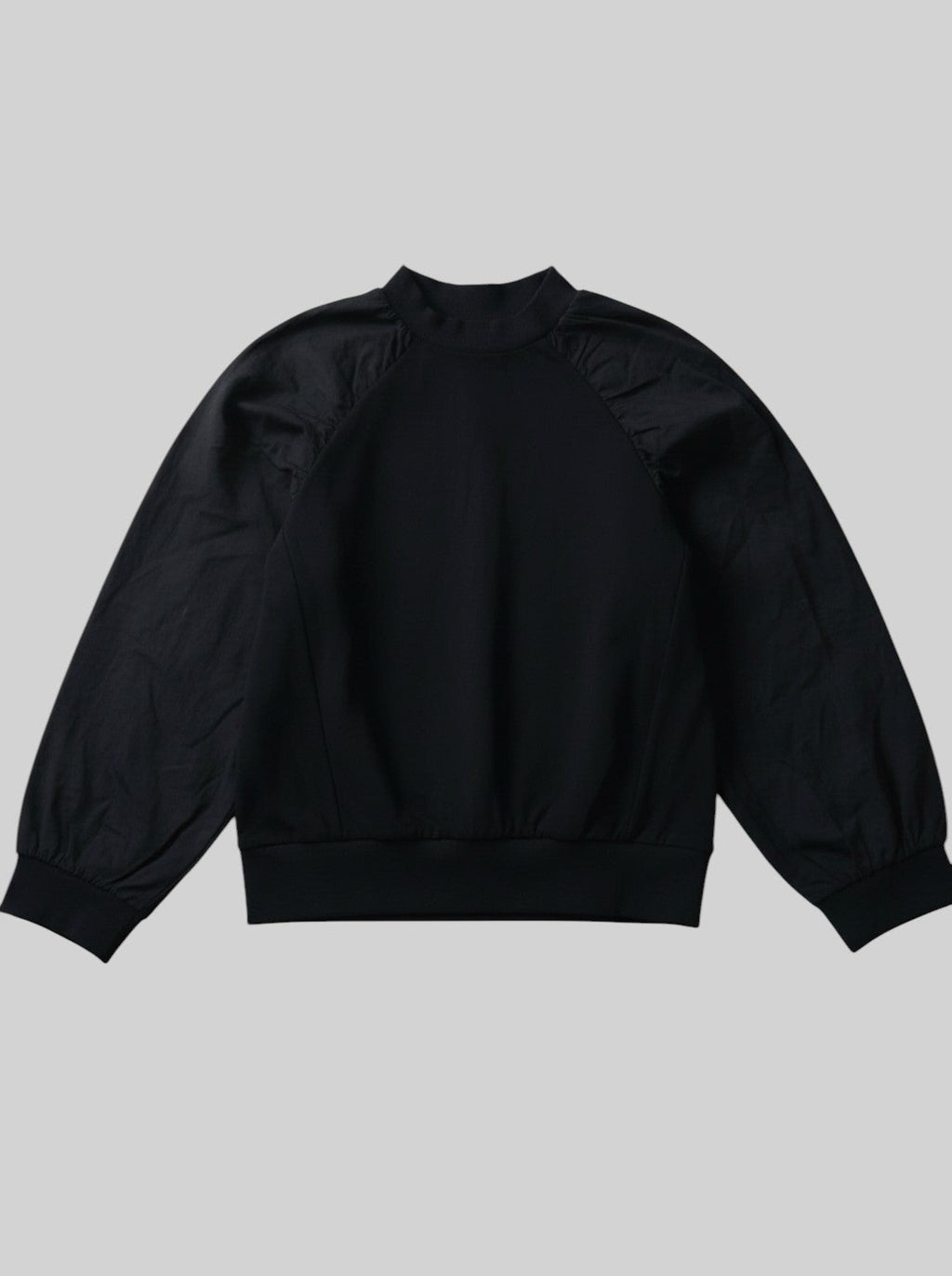 unisex kids black long-sleeve top featuring a soft jersey bodice and contrasting puff sleeves with gathered shoulders and elasticated cuffs