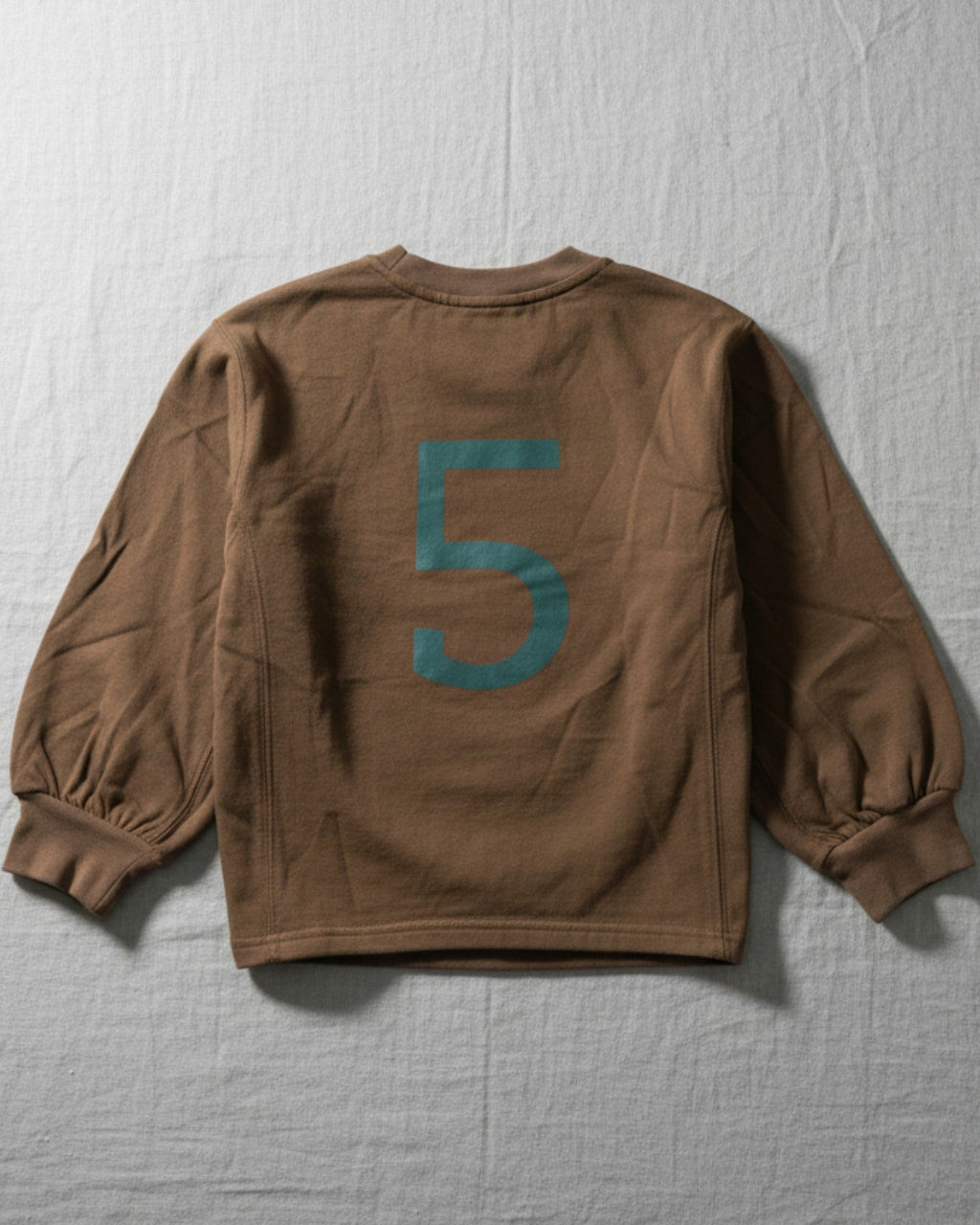 A high-quality, earth-toned kids' top with a modern graphic, designed for durable play and easy mixing and matching with any outfit.