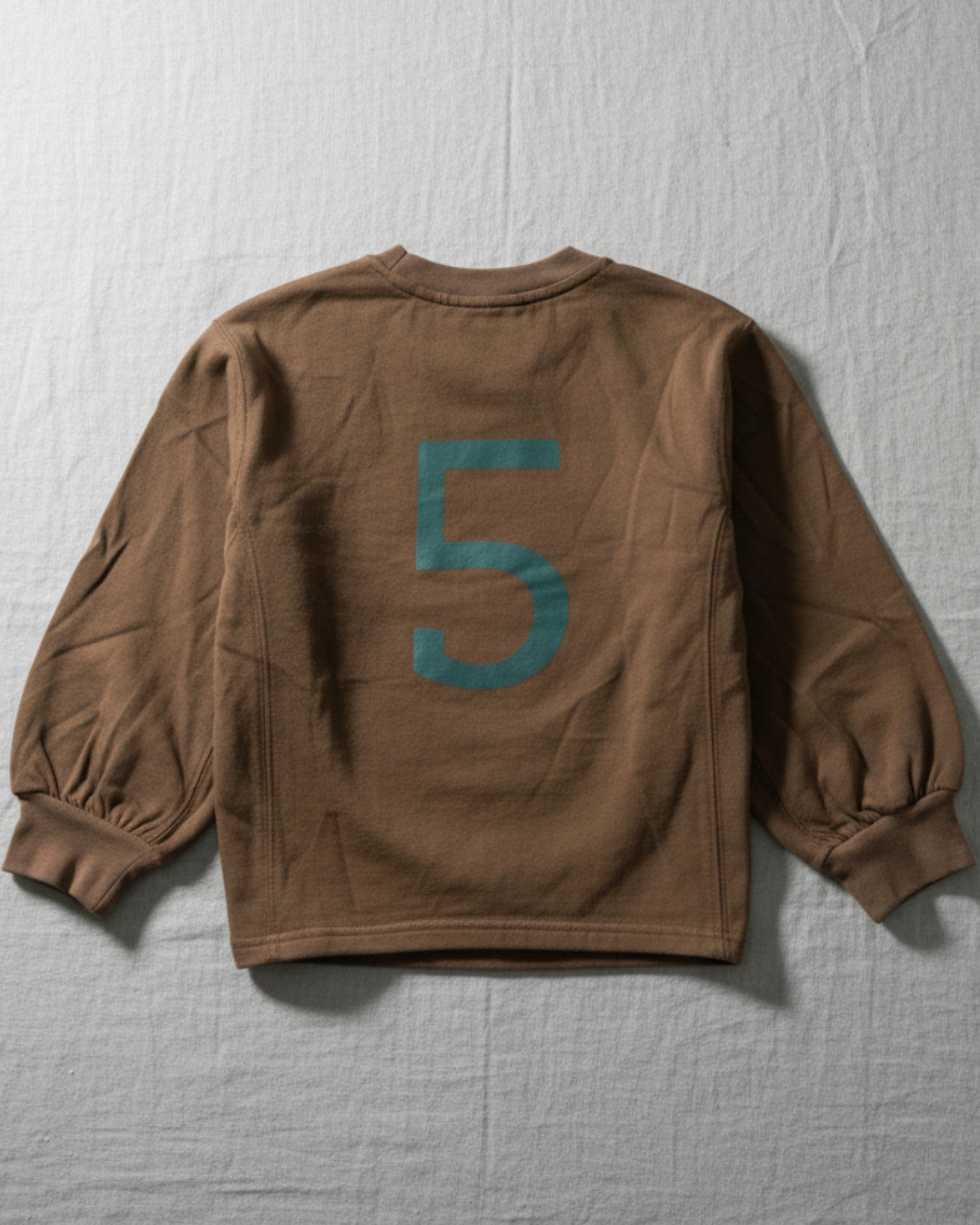 A high-quality, earth-toned kids' top with a modern graphic, designed for durable play and easy mixing and matching with any outfit.