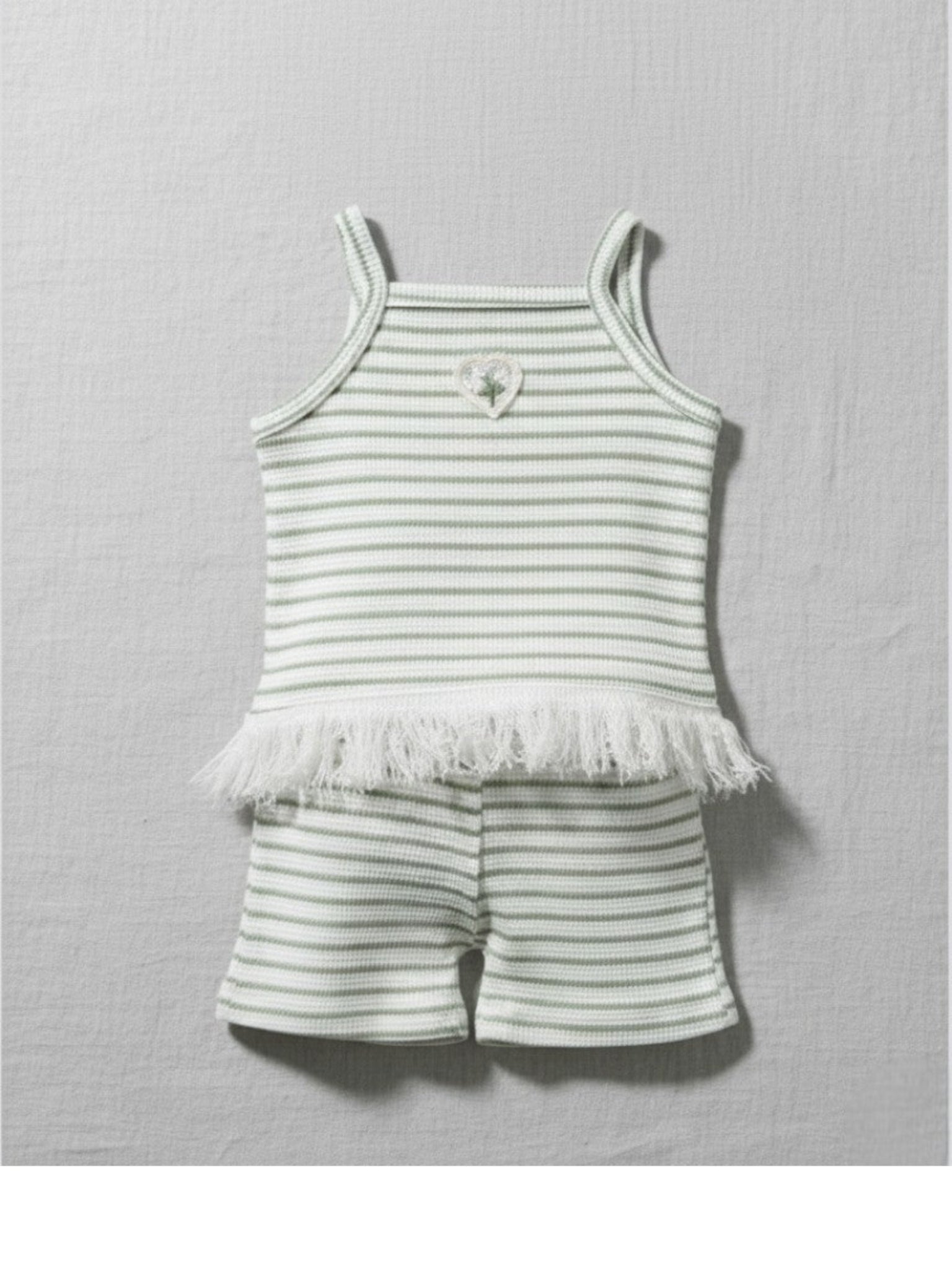 Striped baby outfit with tank top and shorts on a gray background
