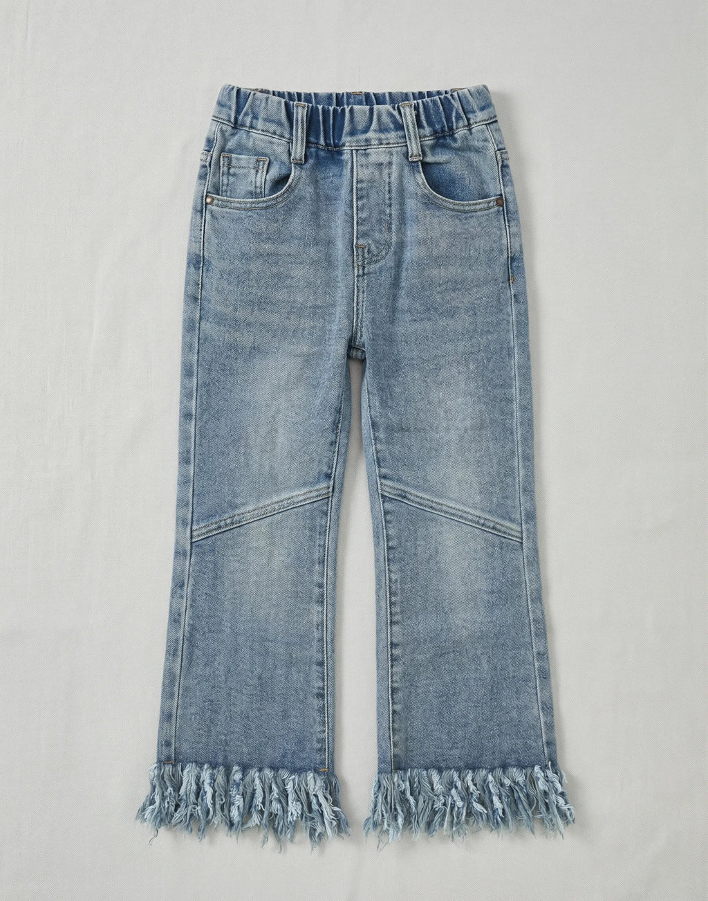 Girls light blue flare jeans featuring a thick fringe hem, elasticated waistband, and decorative knee stitching on a neutral white background.