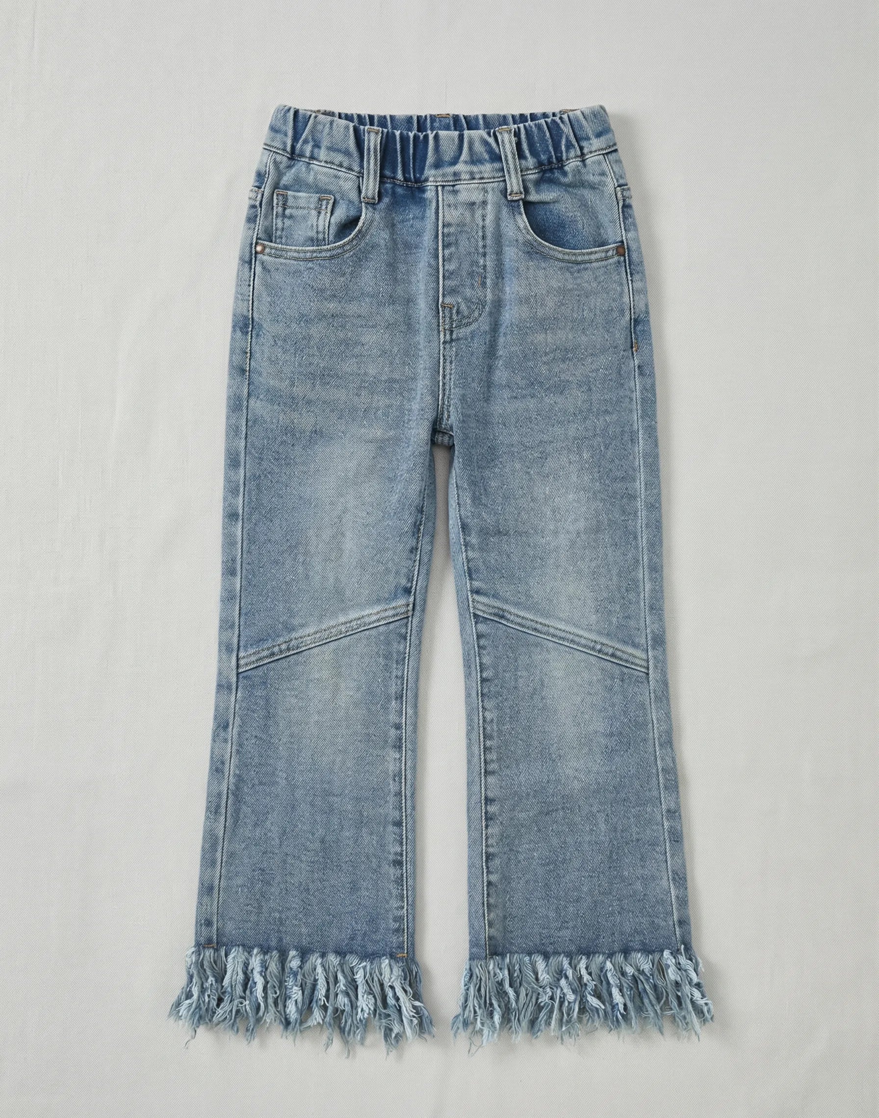 Girls light blue flare jeans featuring a thick fringe hem, elasticated waistband, and decorative knee stitching on a neutral white background.