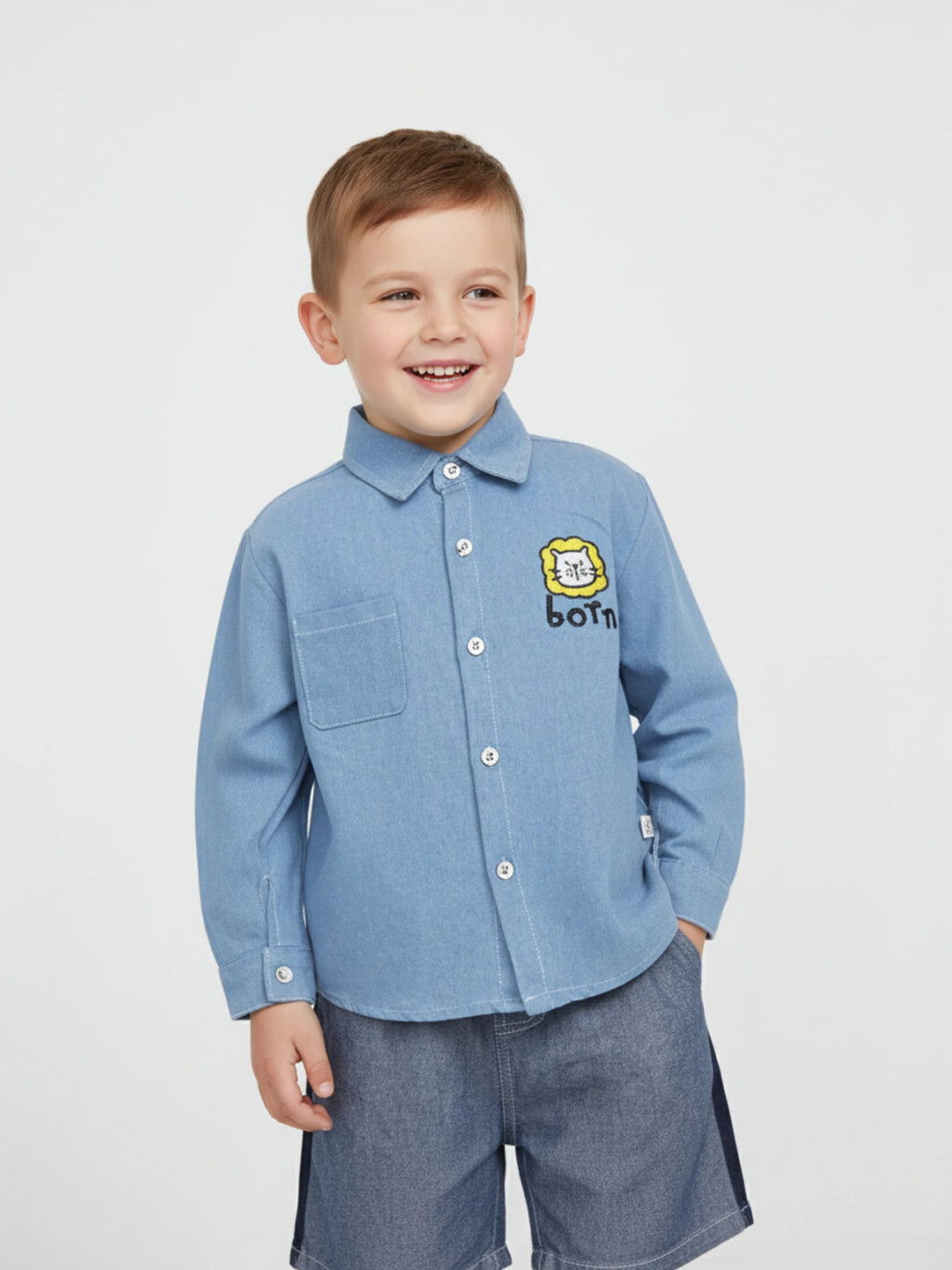 Kids light blue long-sleeve denim button-down shirt featuring a yellow lion embroidery and "Born" graphic