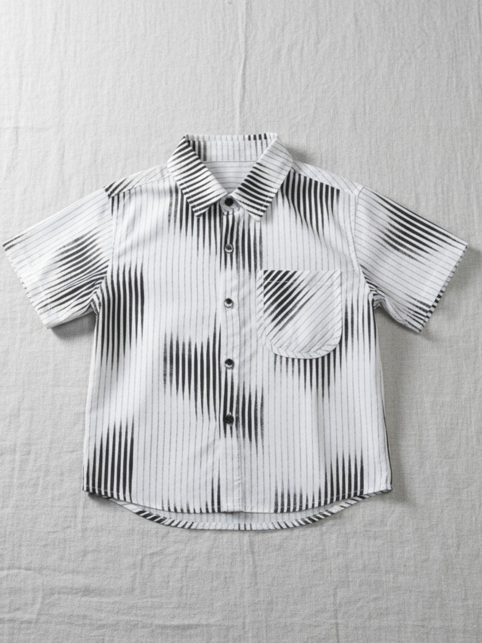 Black and white striped shirt on a textured gray surface