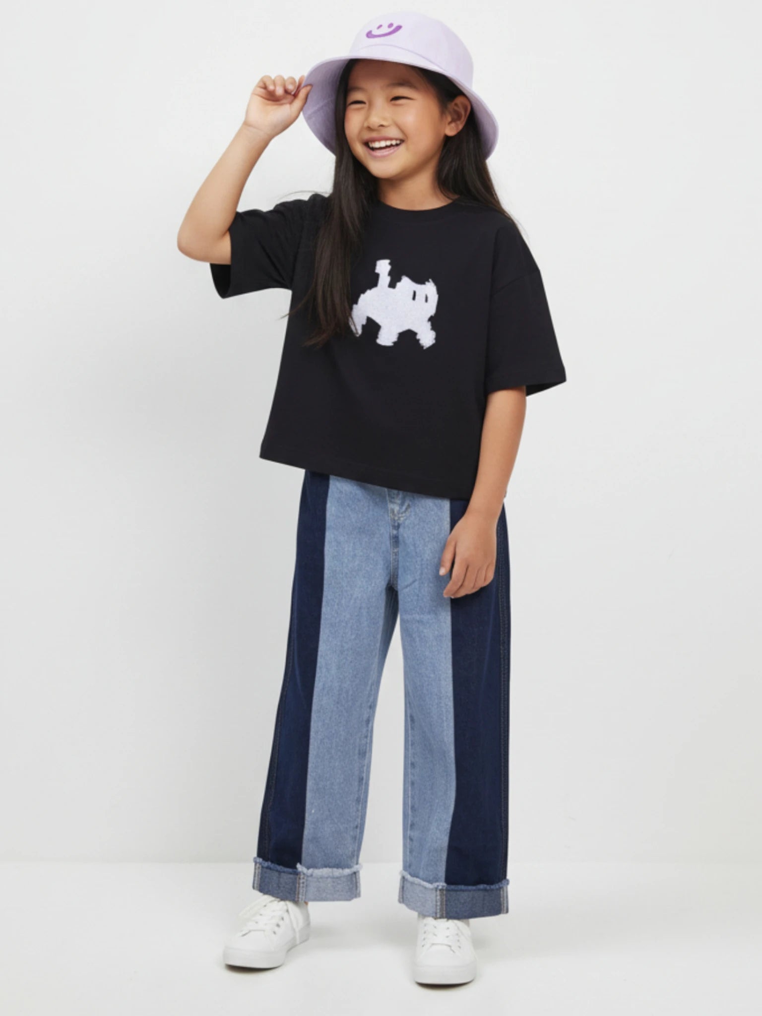 Kids blue denim jeans featuring a two-tone light and dark patchwork design, a gathered elastic waistband, and raw frayed hem