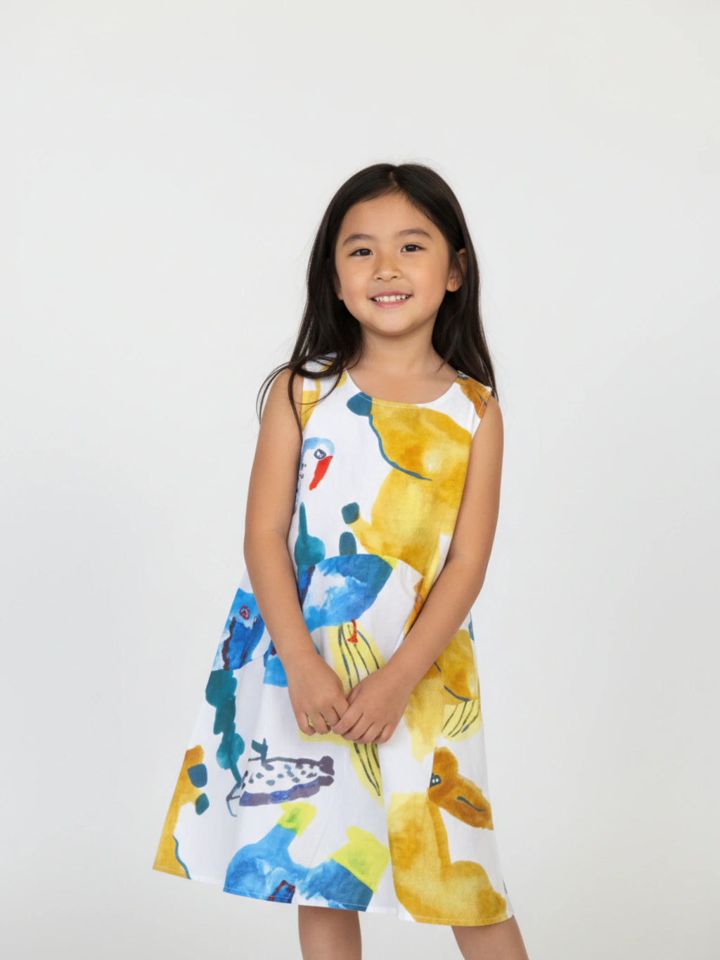 Kids sleeveless white A-line dress featuring a vibrant, oversized abstract botanical and tropical watercolor print in yellow, blue, and ochre.