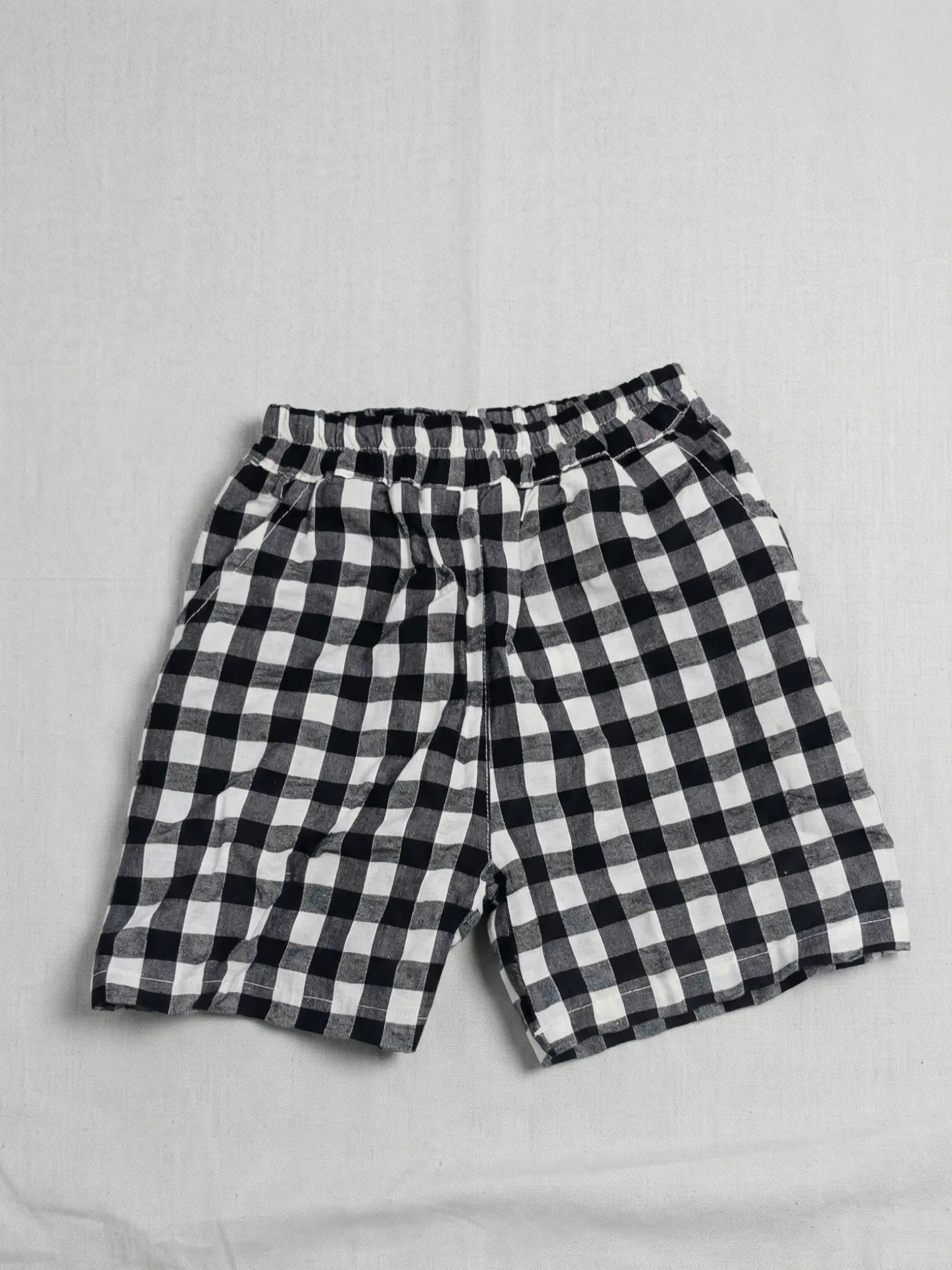 Black and white checkered shorts on a light gray background