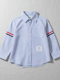 Kids blue and white vertical striped long sleeve button-down shirt featuring red, white, and navy armbands and a chest pocket.
