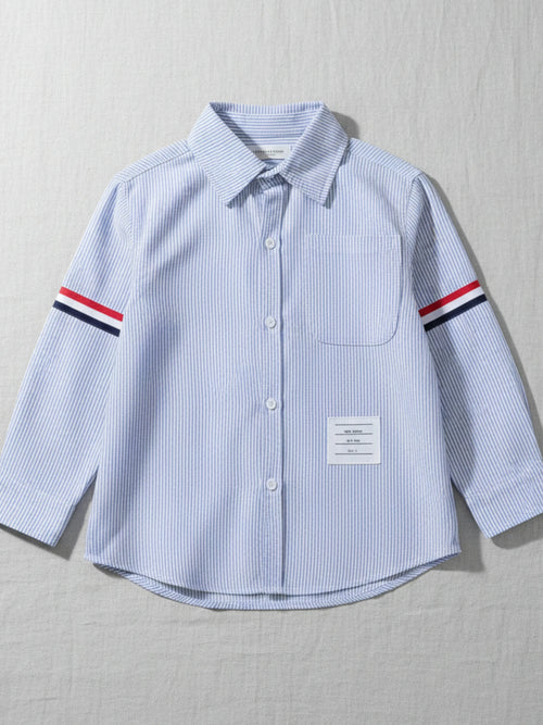 Kids blue and white vertical striped long sleeve button-down shirt featuring red, white, and navy armbands and a chest pocket.