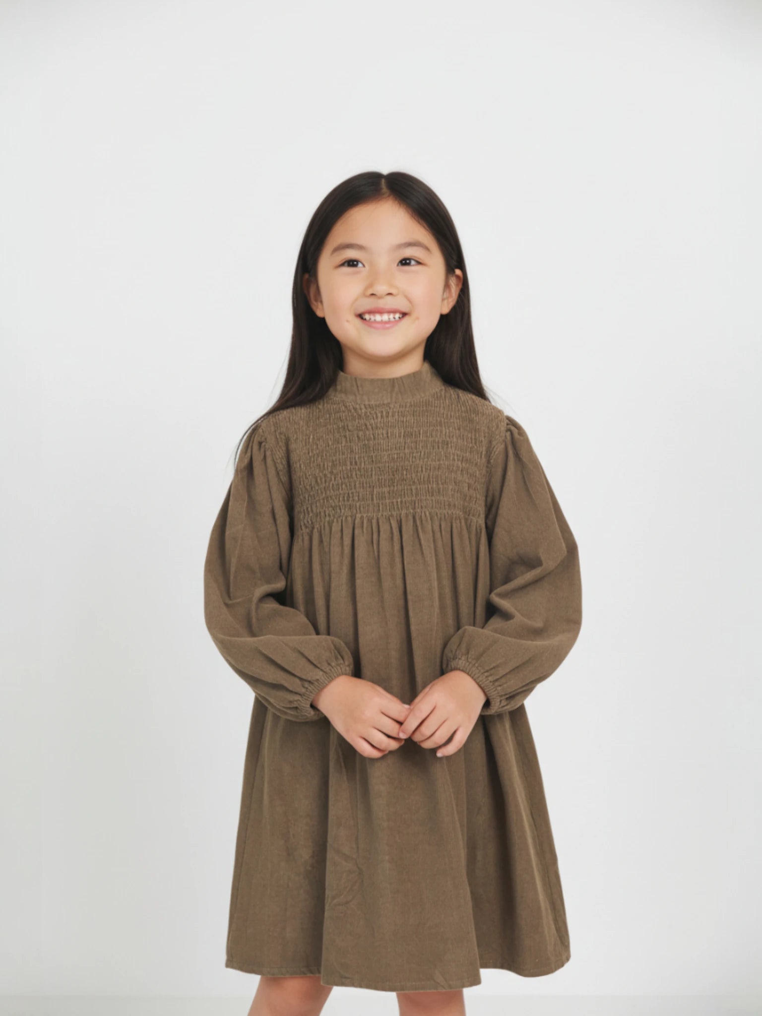 long-sleeve brown corduroy dress featuring a high smocked bodice and voluminous balloon sleeves on a white studio background.